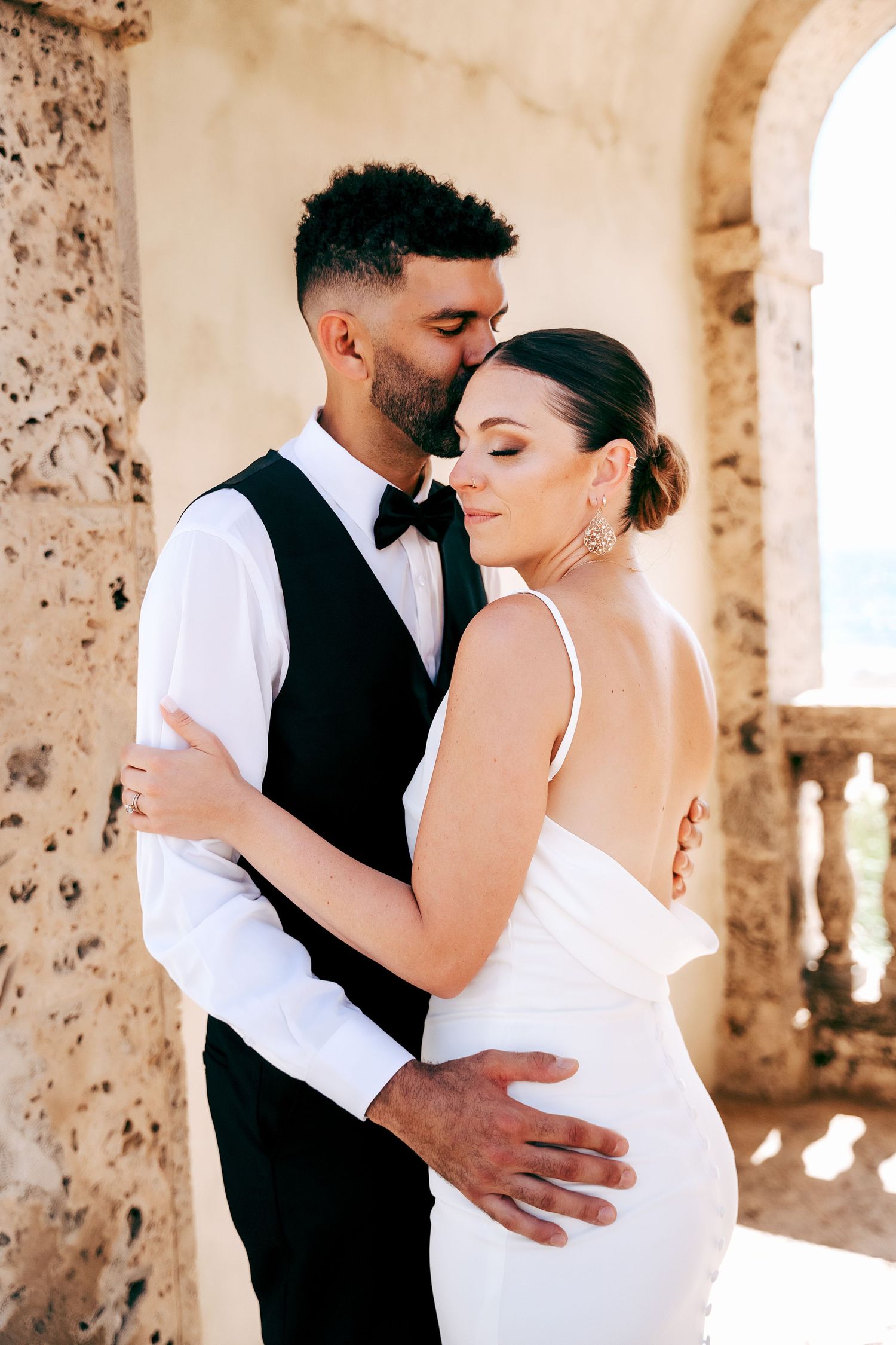 Romantic wedding photoshoot in rustic stone building with dramatic lighting.