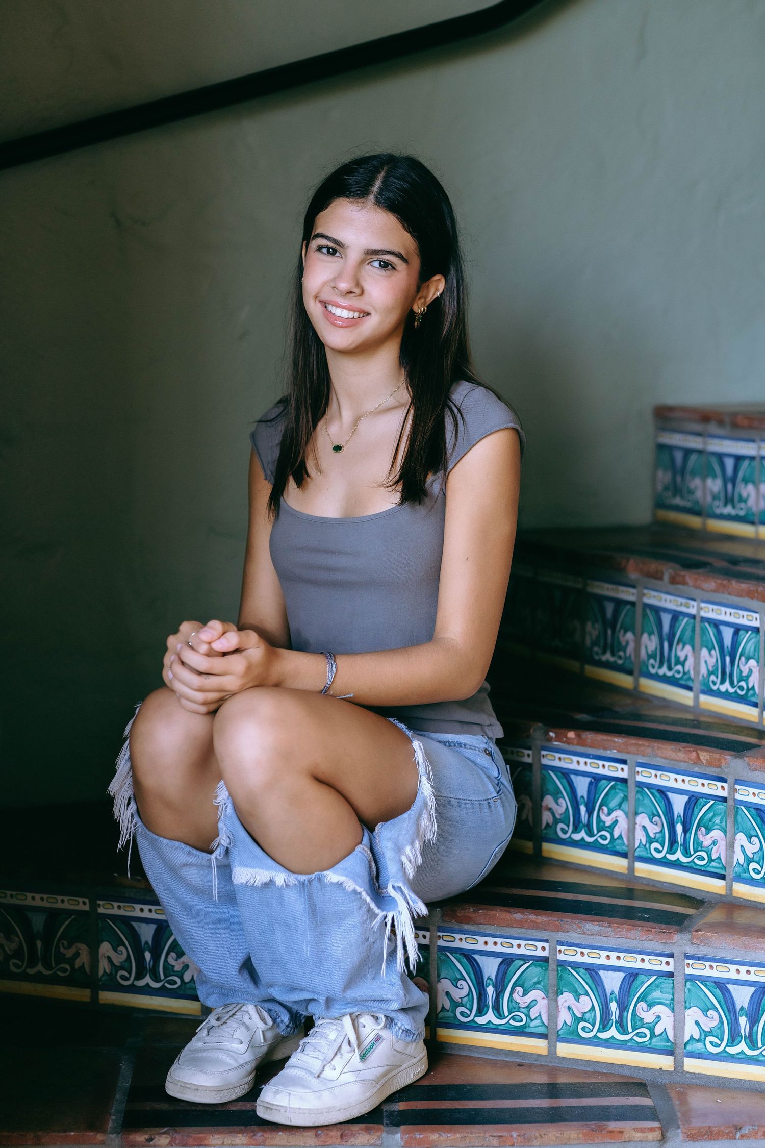 A casual portrait series on decorative tiled steps showing relaxed seated poses.