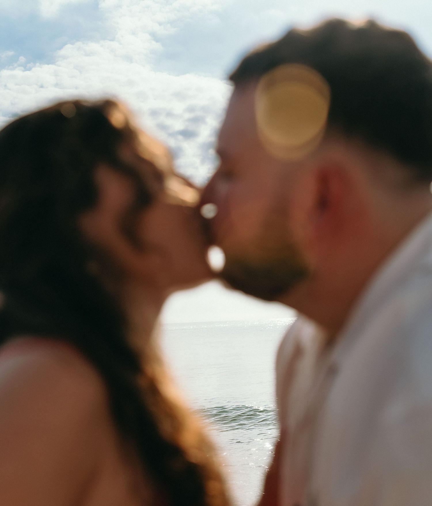 Soft focus romantic beach portraits with ocean backdrop.