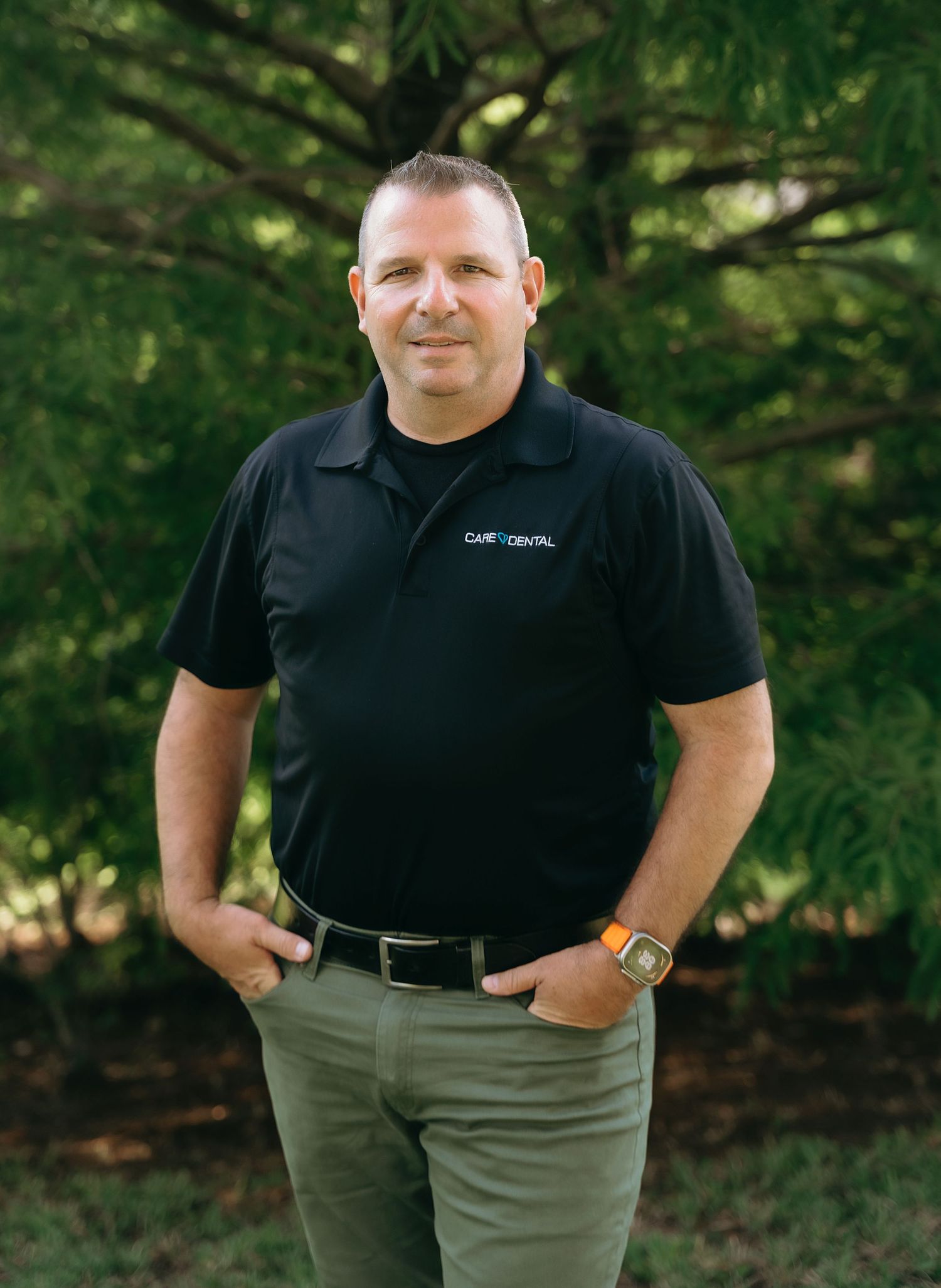 Business casual portraits showing confident poses in black polo and khaki pants outdoors.