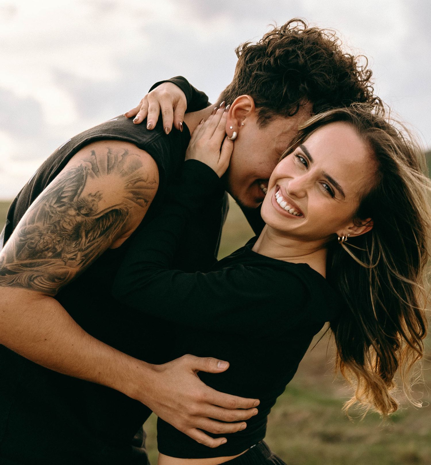 Playful outdoor couple photoshoot with natural lighting and dramatic poses.