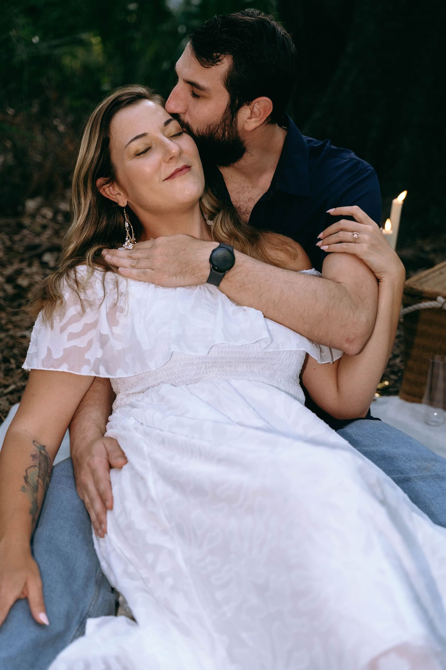 A couple in casual attire shares tender moments during an outdoor photo session.