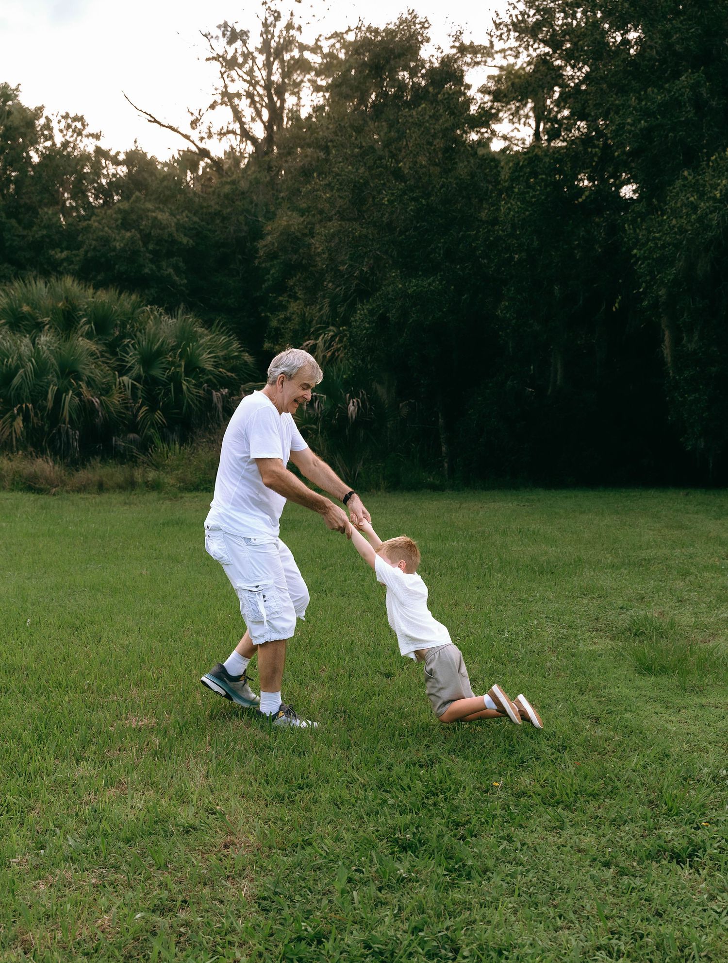 Action shots of people running and jumping on grass in matching white outfits.
