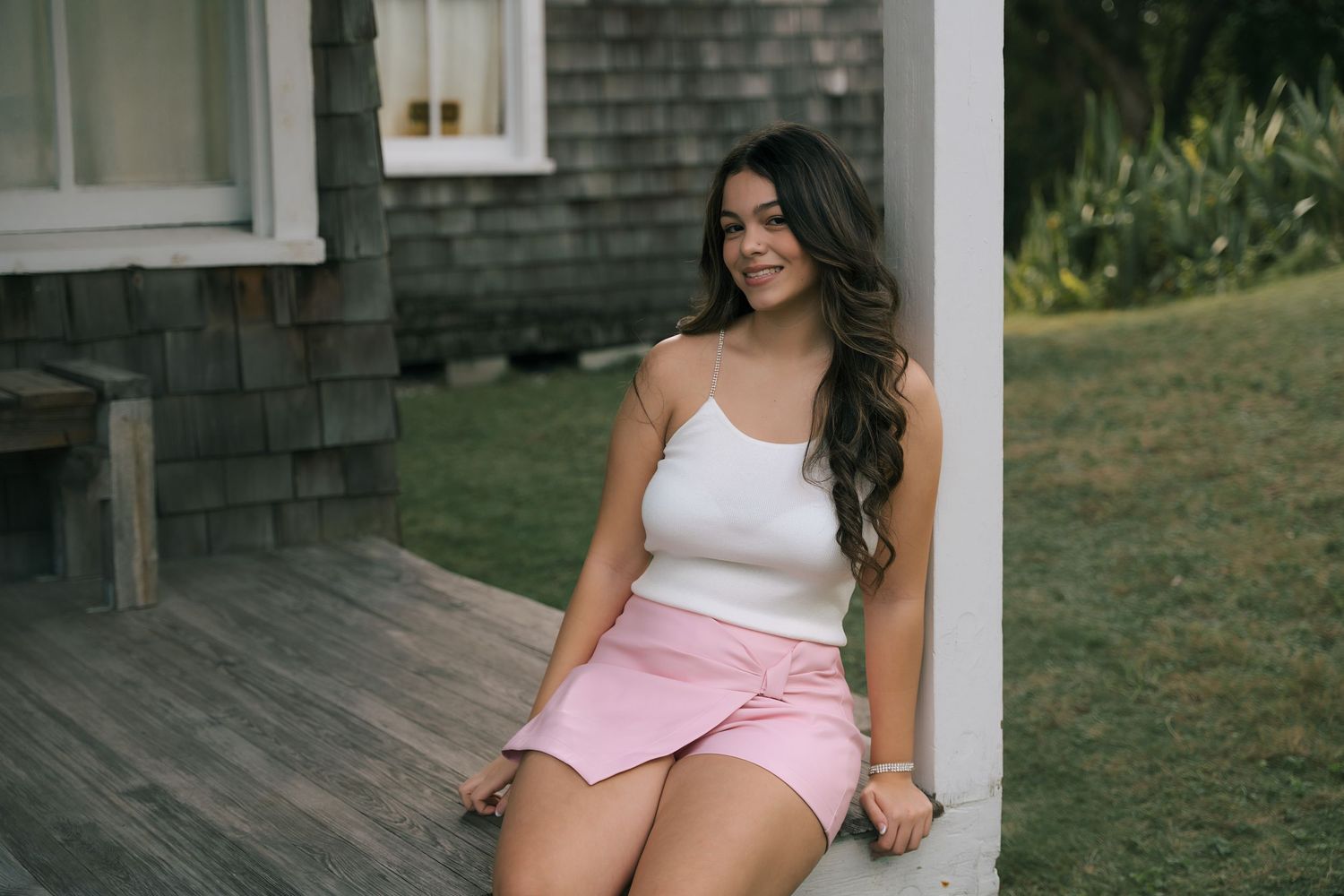 Casual fashion poses on wooden deck with rustic shingle background.
