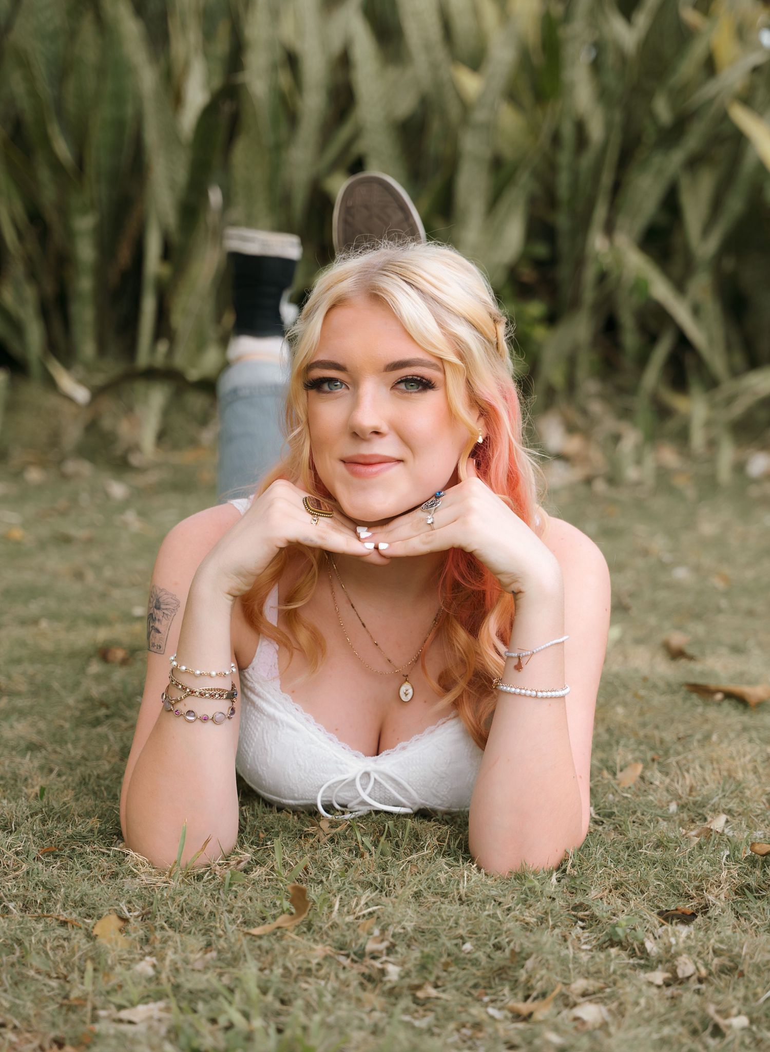 Outdoor portrait session on grass with natural garden backdrop.