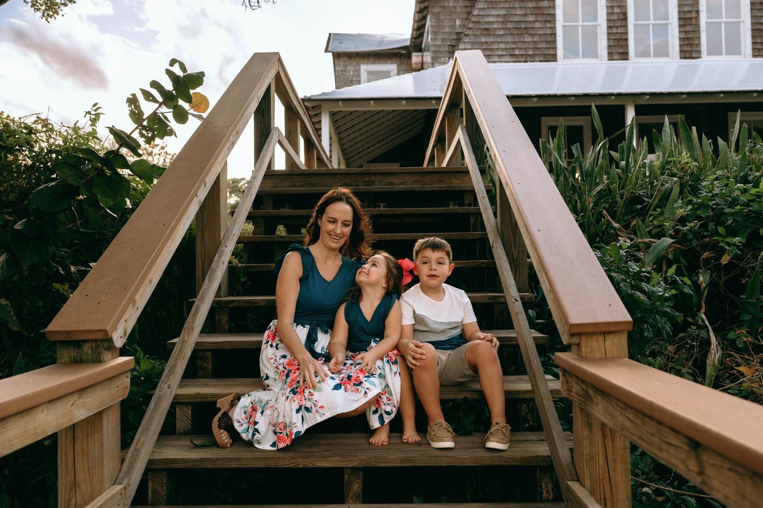 Family enjoying a fun moment together on wooden stairs at sunset.