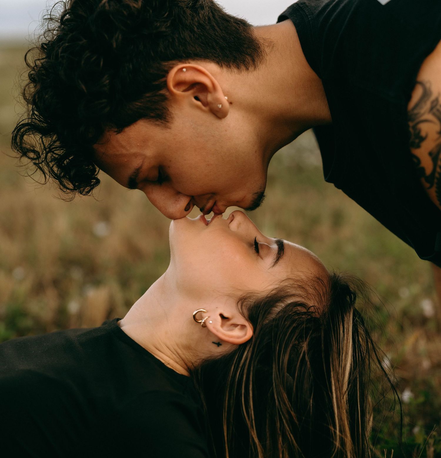 Close-up of romantic couple sharing intimate moment in natural setting.