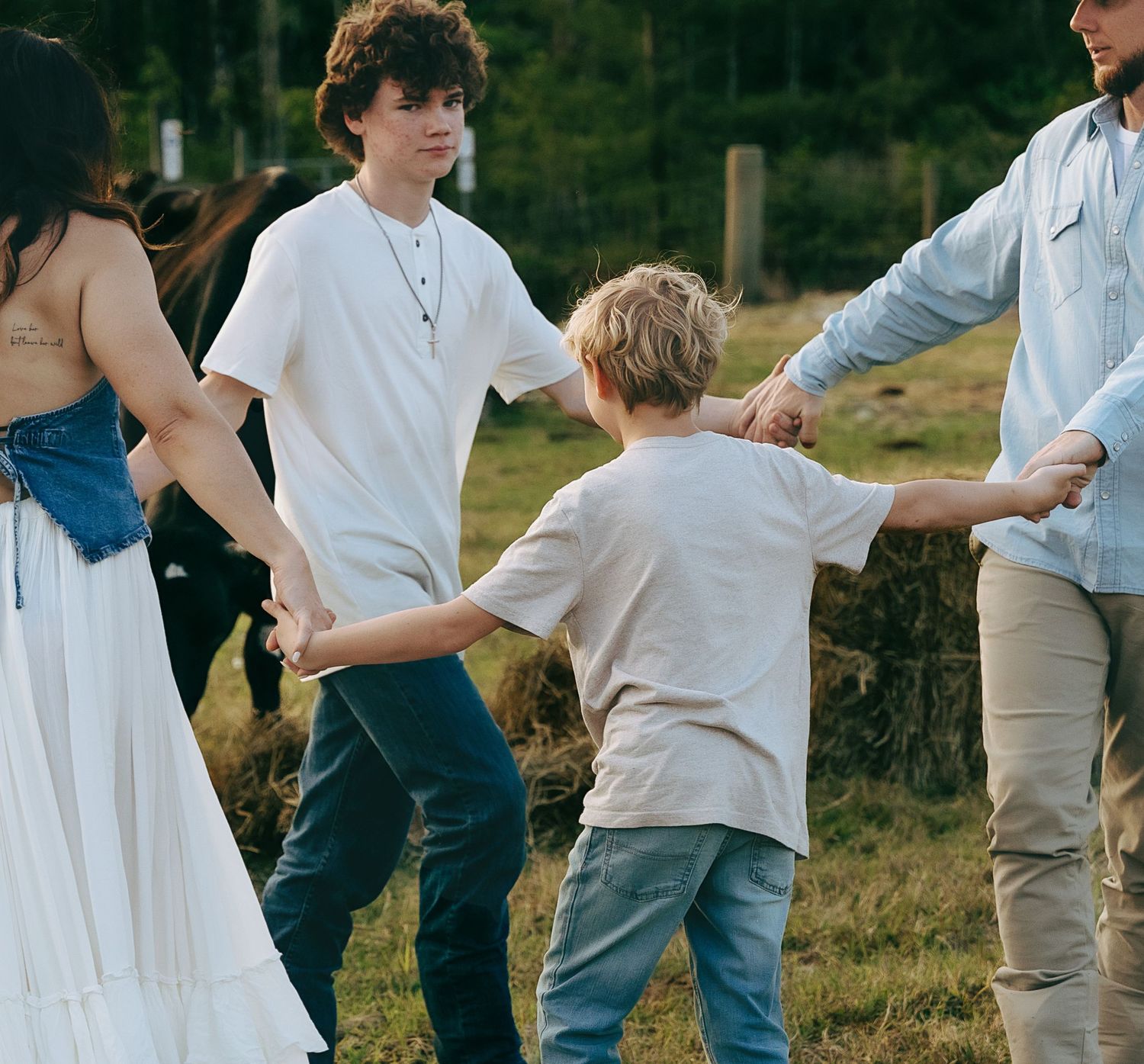 Group of people standing together in a line outdoors during golden hour.