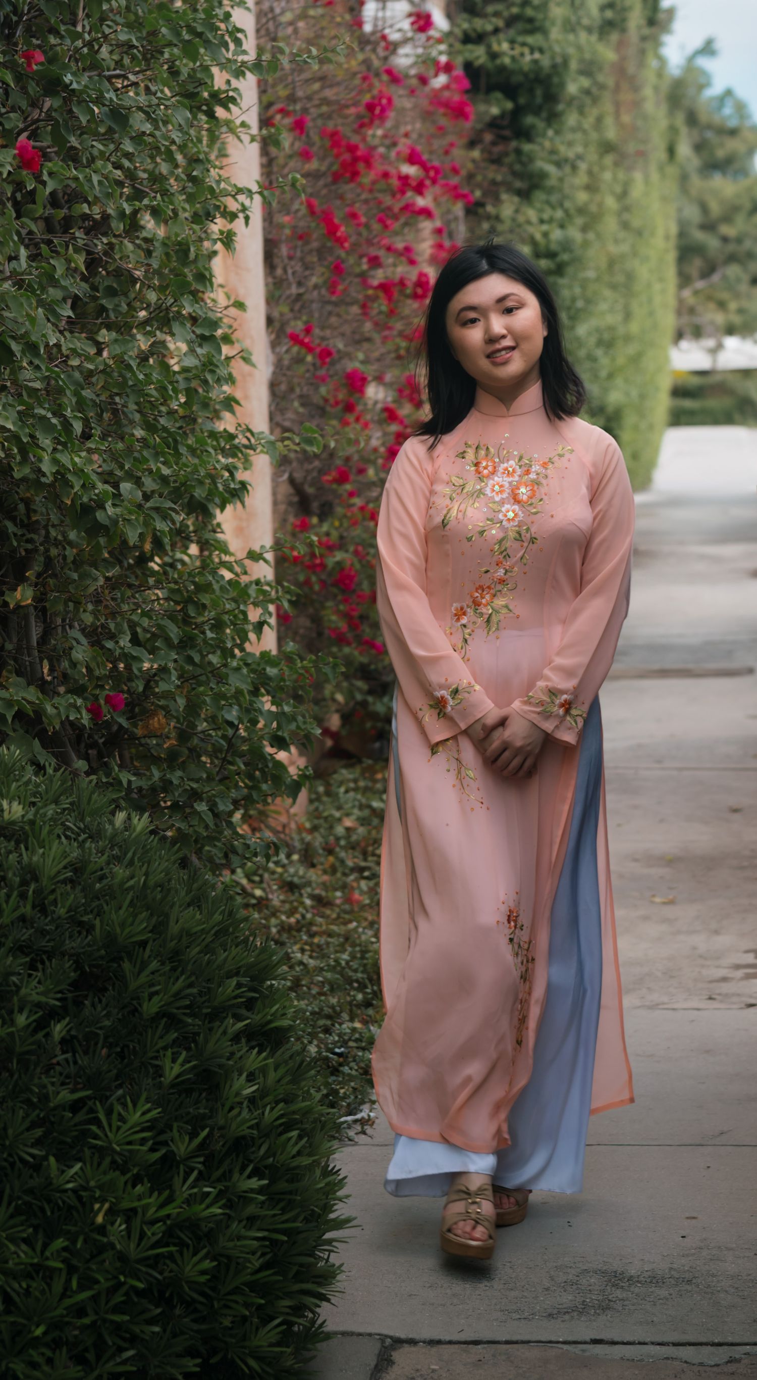 A delicate pink traditional dress with floral embroidery paired with blue pants.