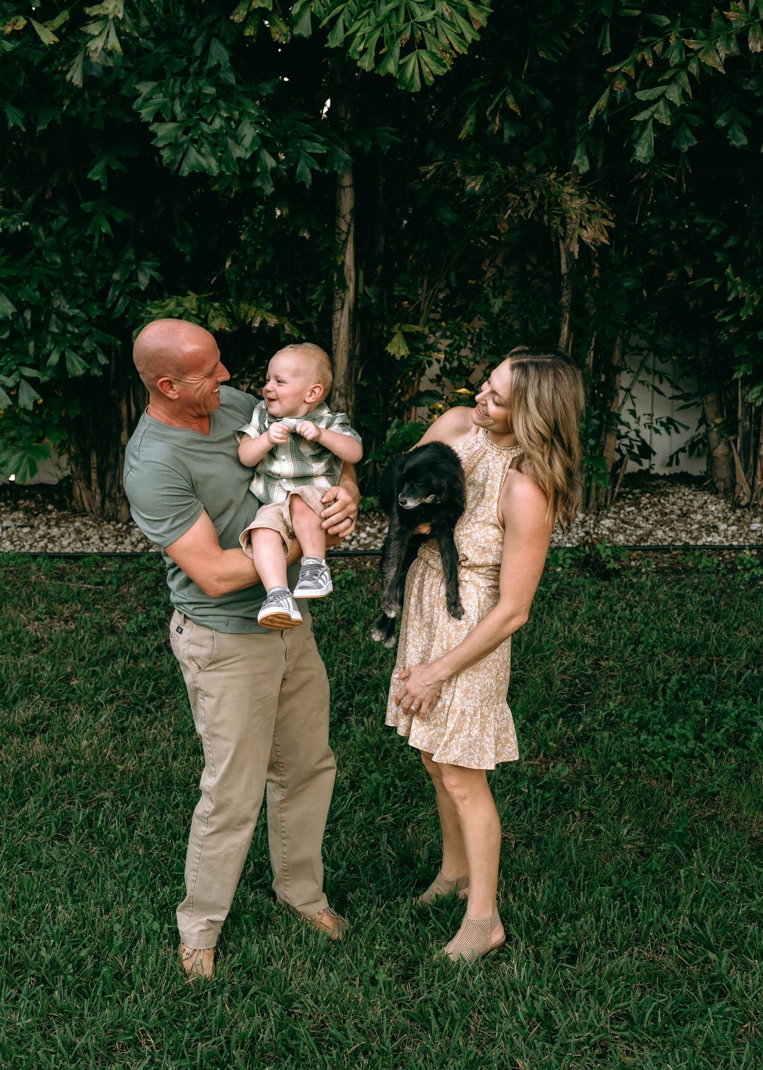 Family playing and laughing together in green backyard.
