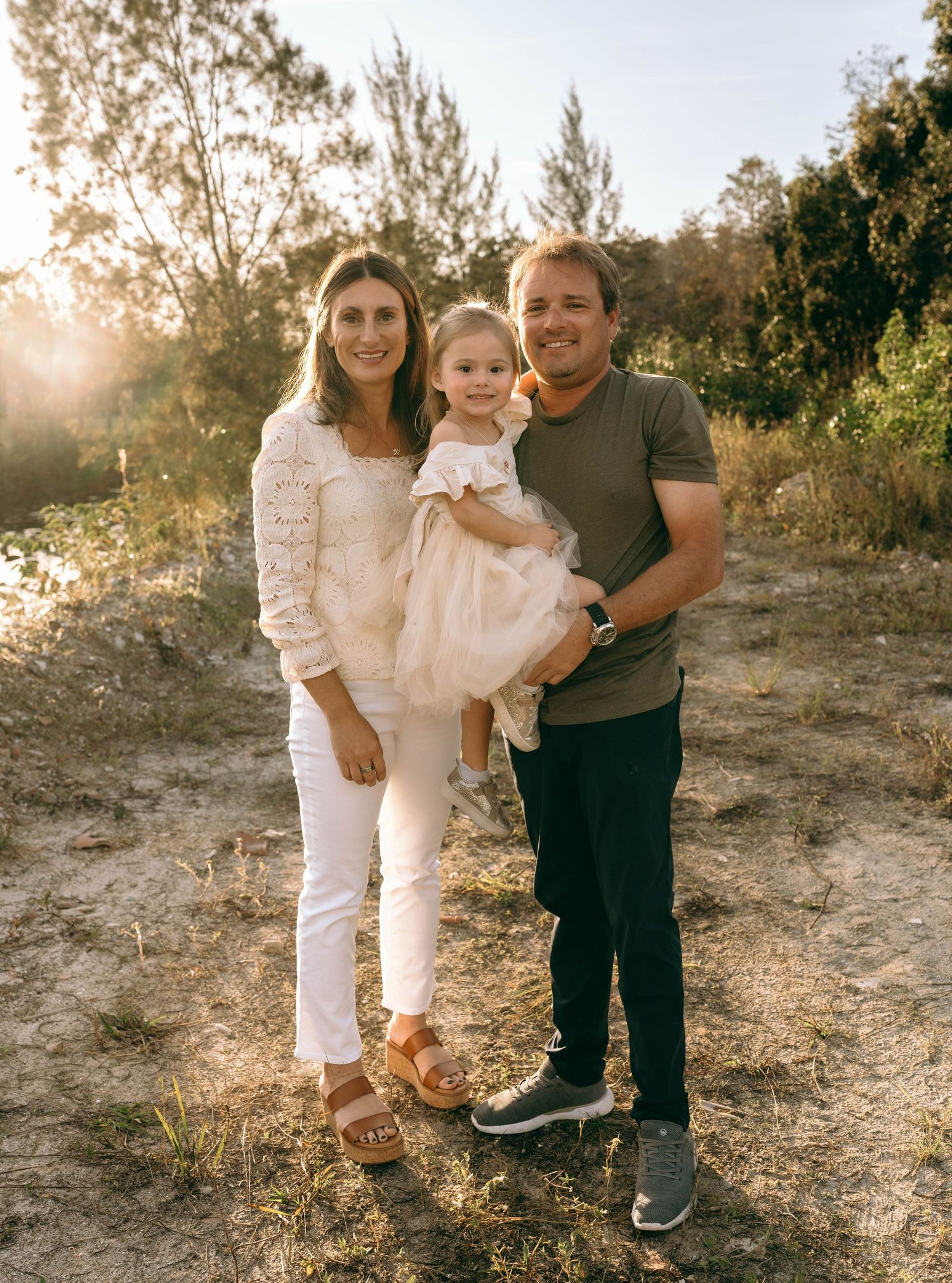 Family portrait session at golden hour in a natural outdoor setting.