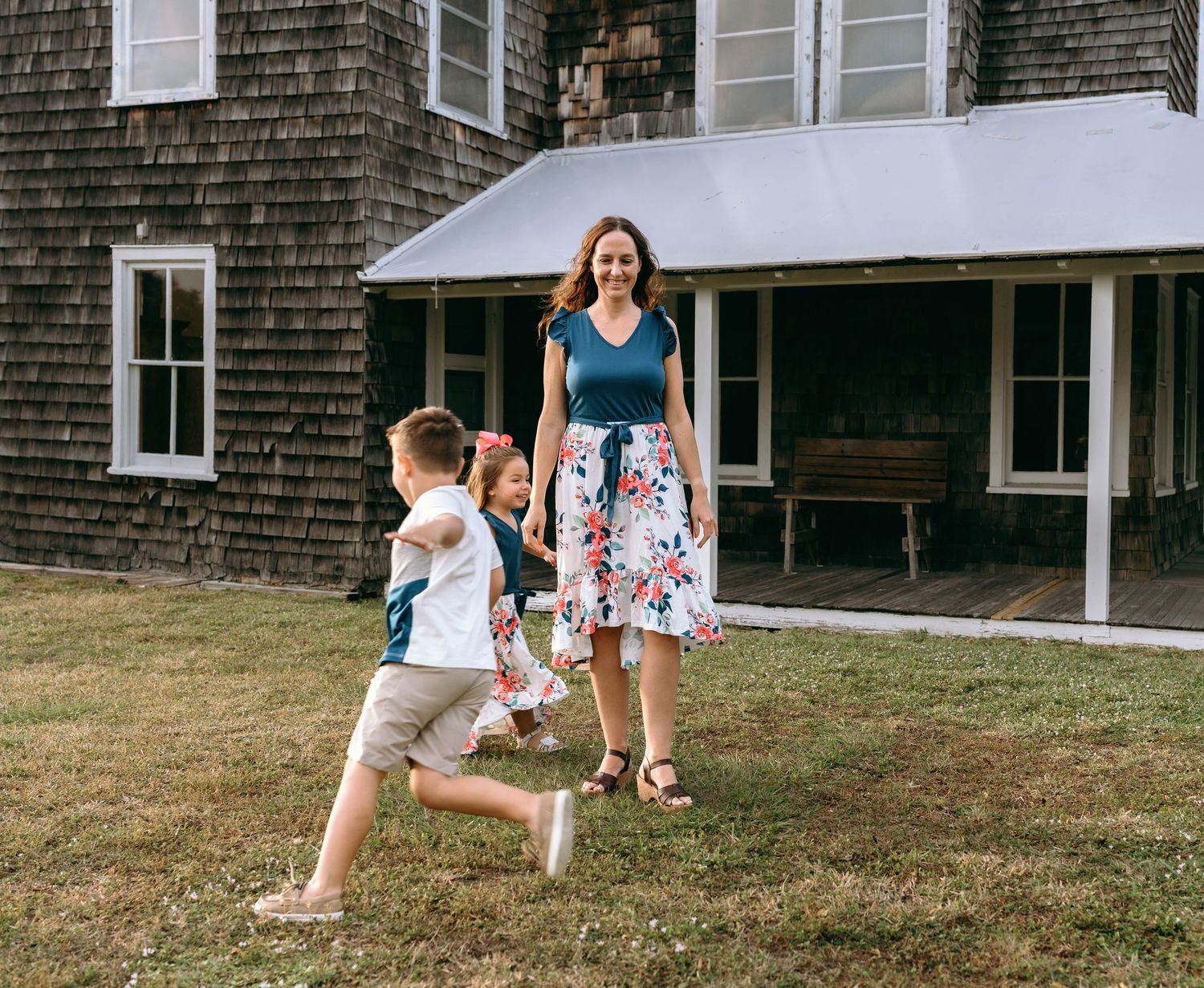Playful scene outside a classic New England style house with wooden shingles.