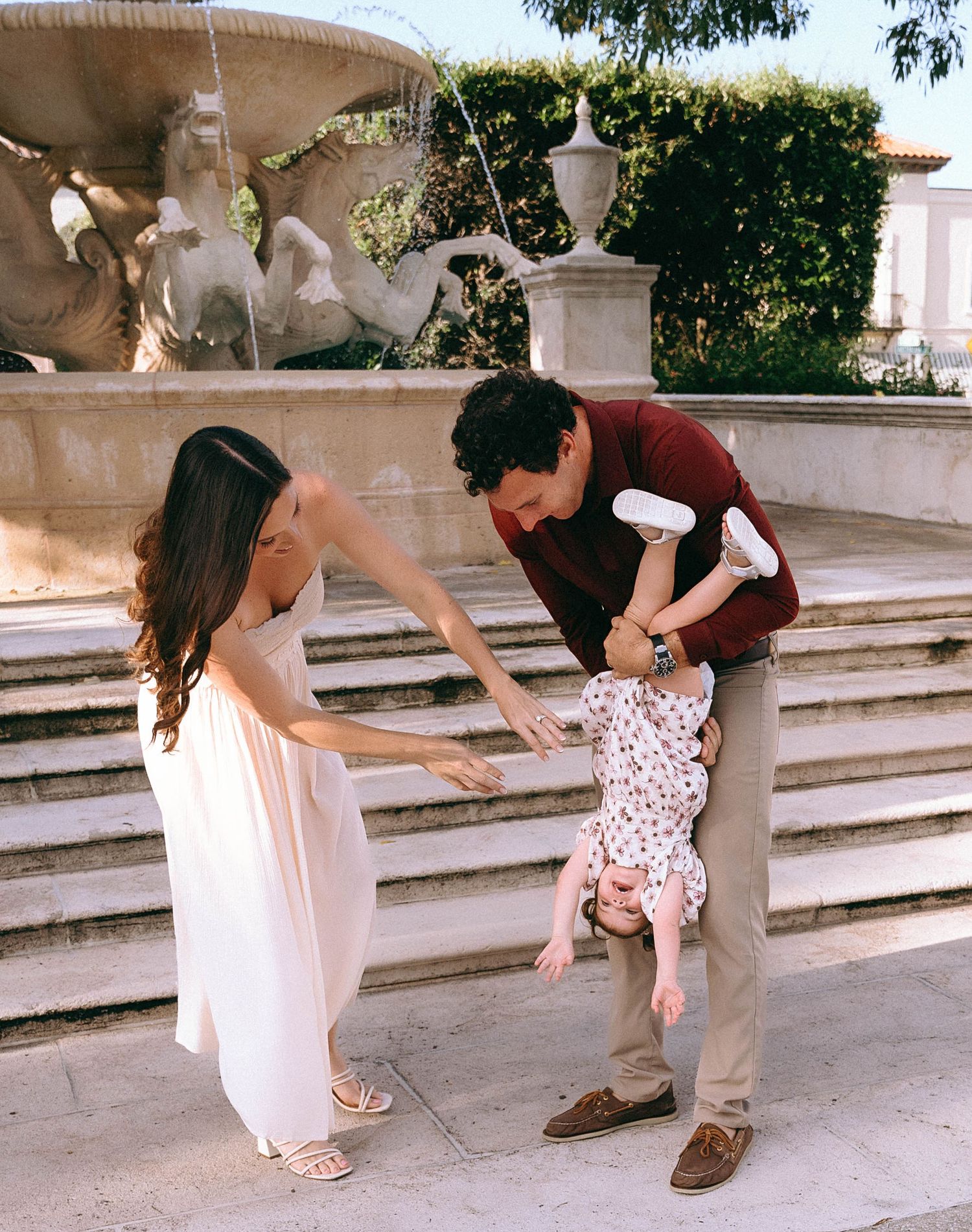 Candid moments of interaction on decorative stone steps in a garden setting.