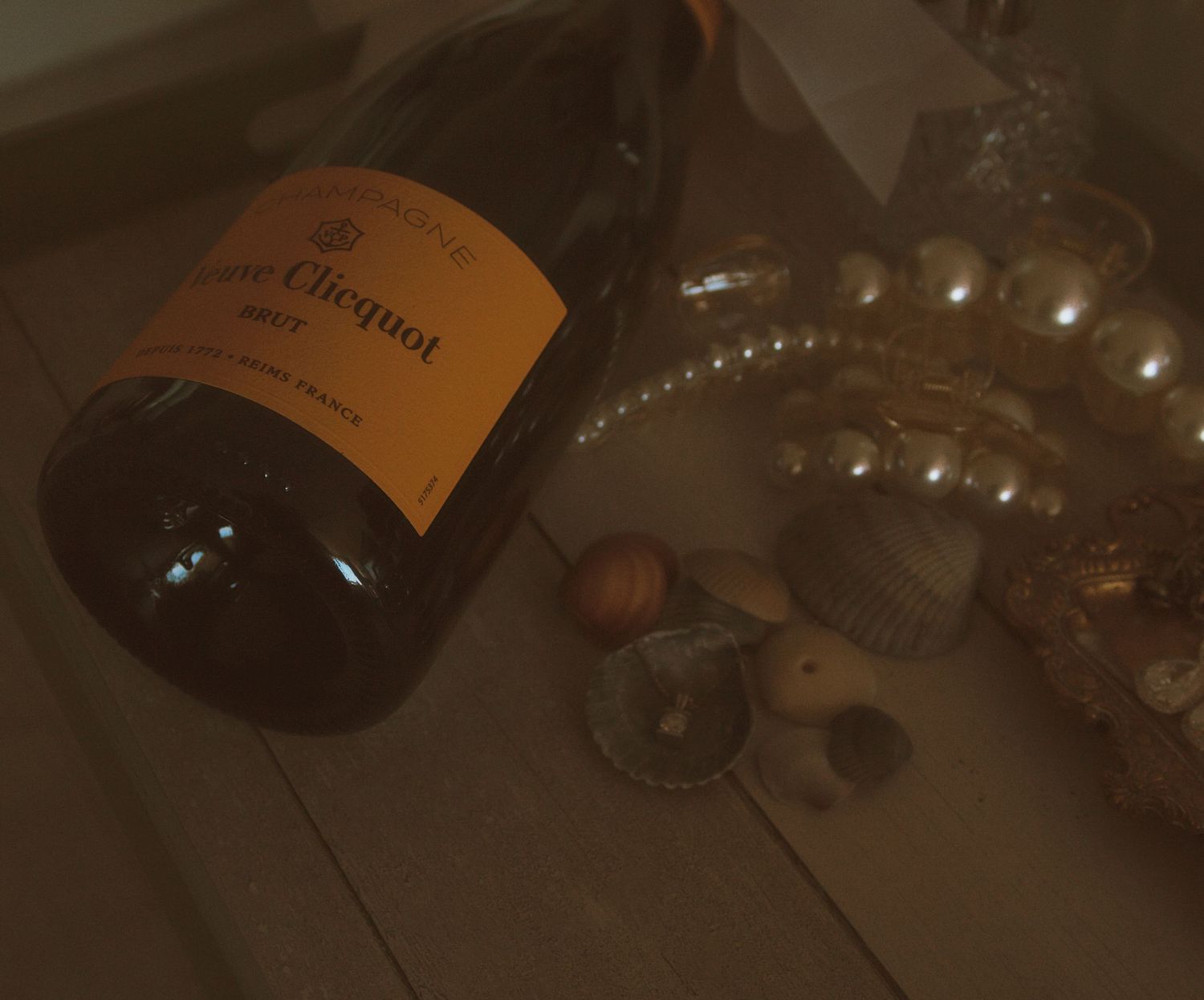 Dark bottles of champagne arranged on a reflective surface.