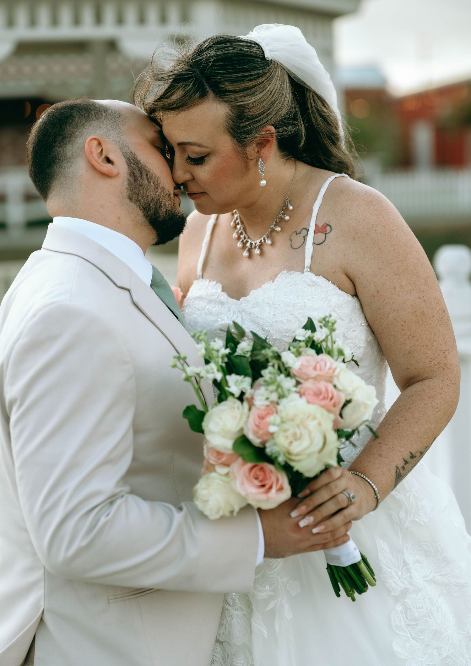 Close-up shots of a bride holding white and pink roses in her wedding bouquet.