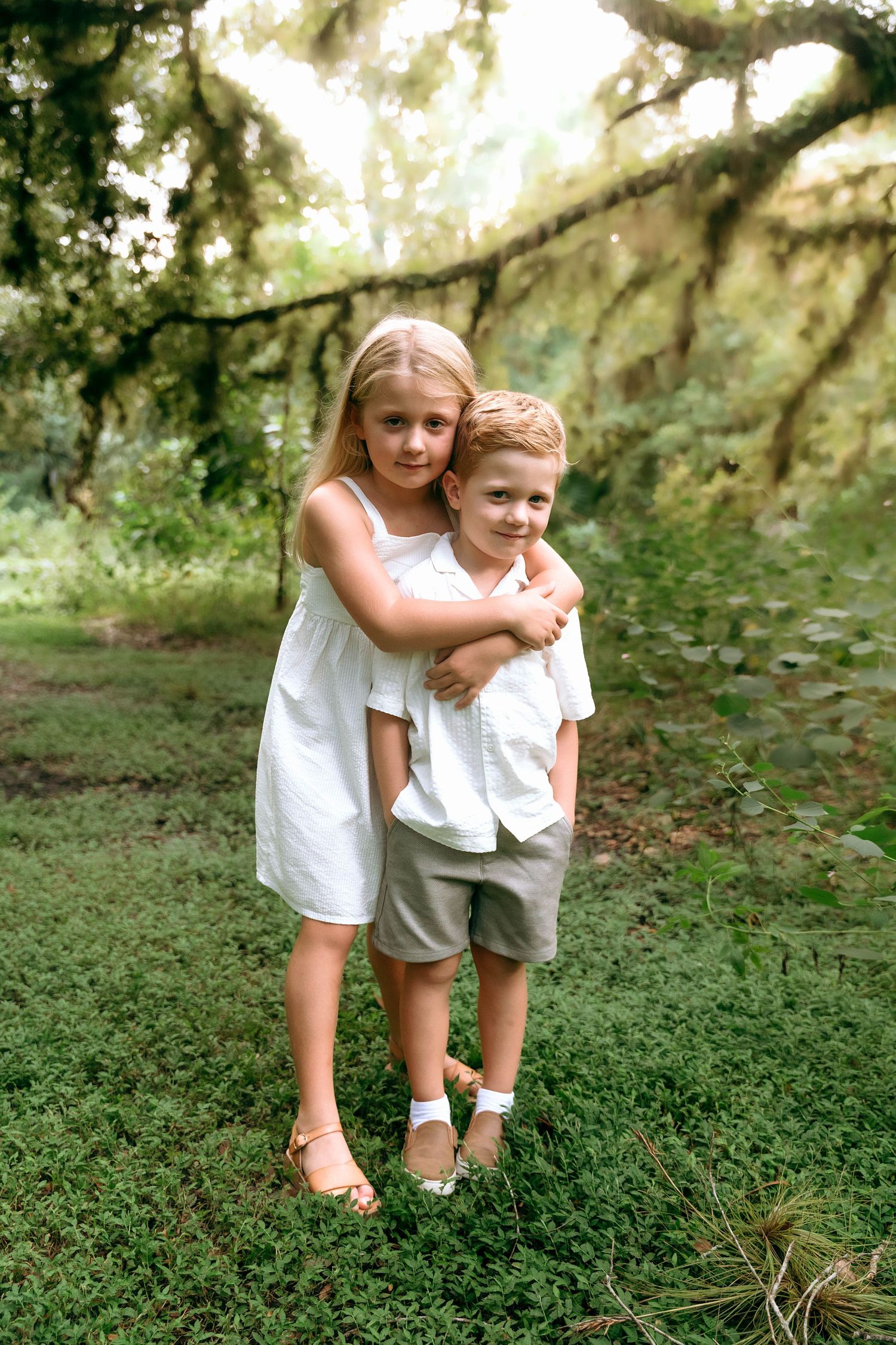 Playful moment captured between two people in a mossy garden setting.