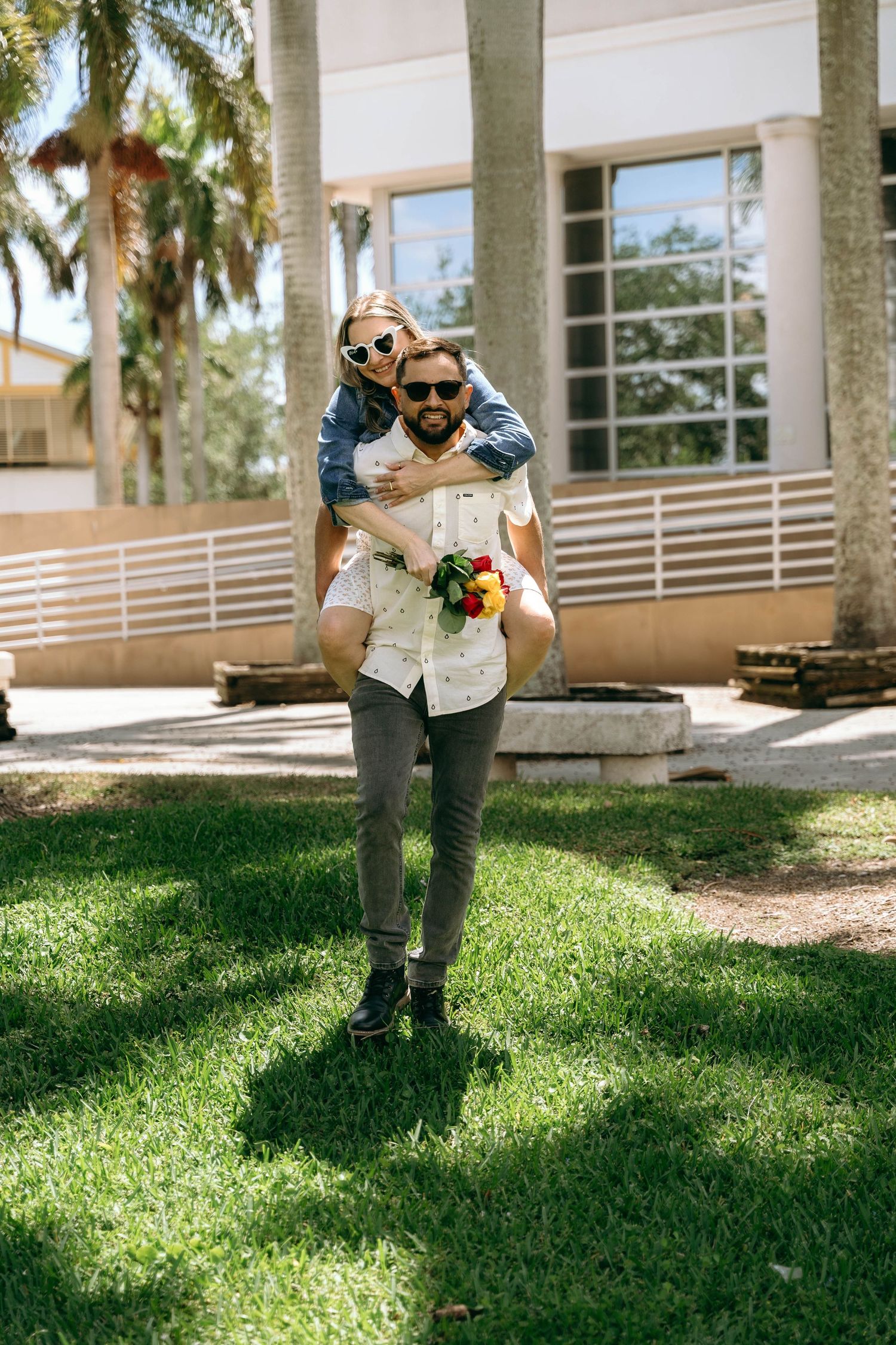 A sequence of playful jumping poses on sunny grass with palm trees in the background.