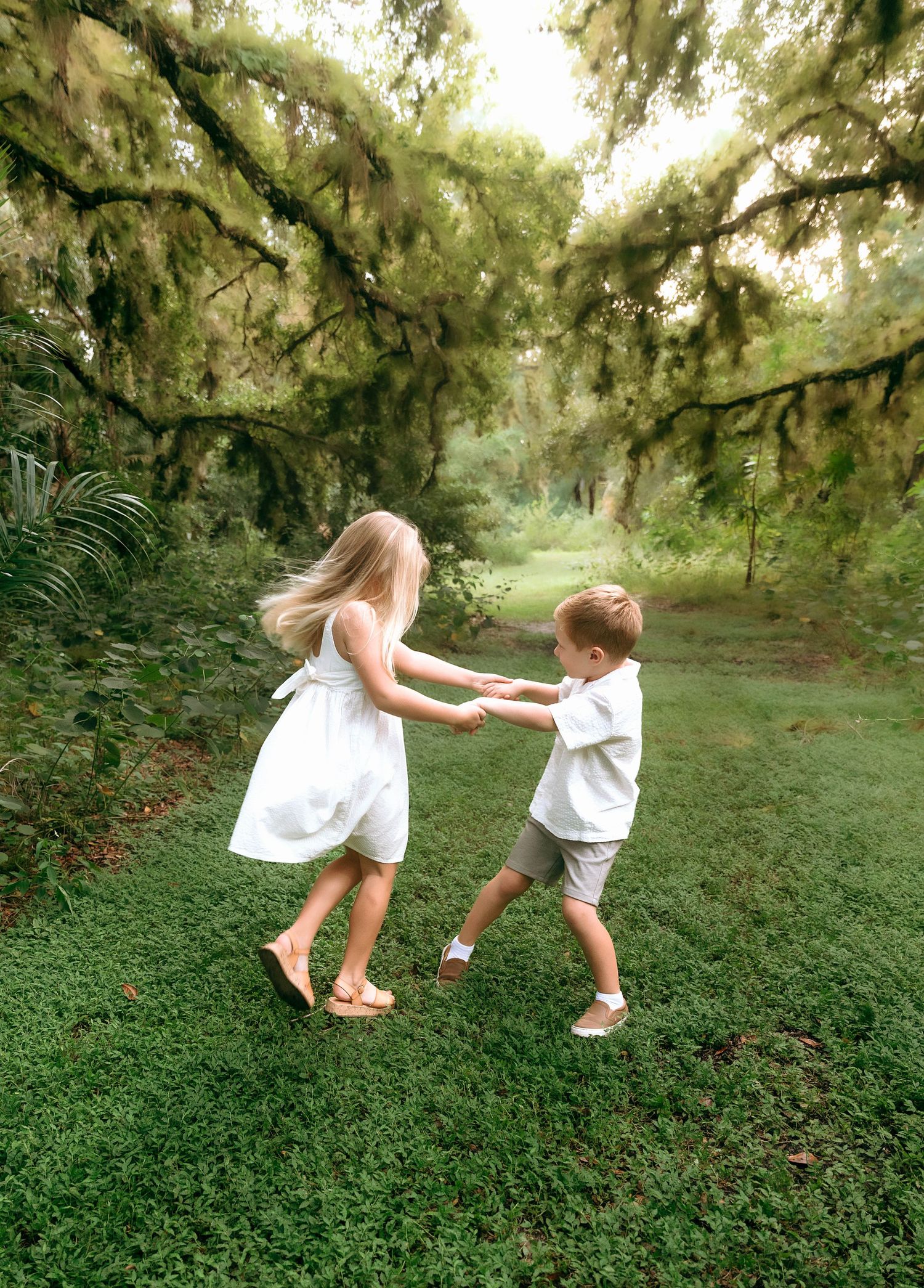 Children playing and running through a lush green garden path.
