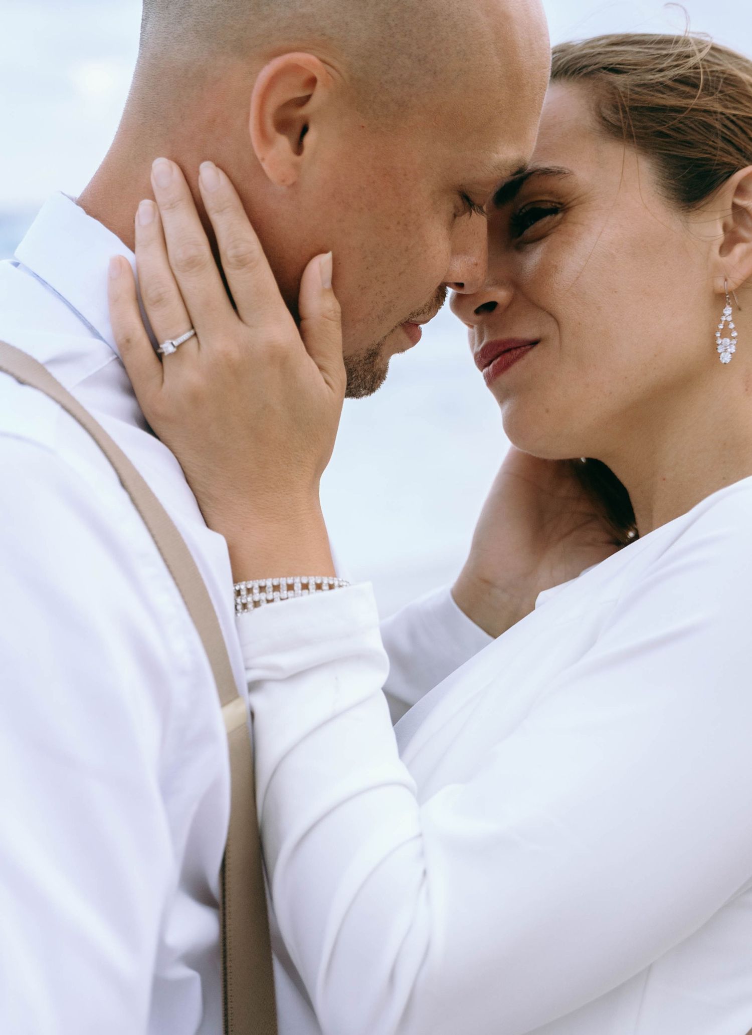 Intimate close-up of couple in white clothing sharing a tender moment.
