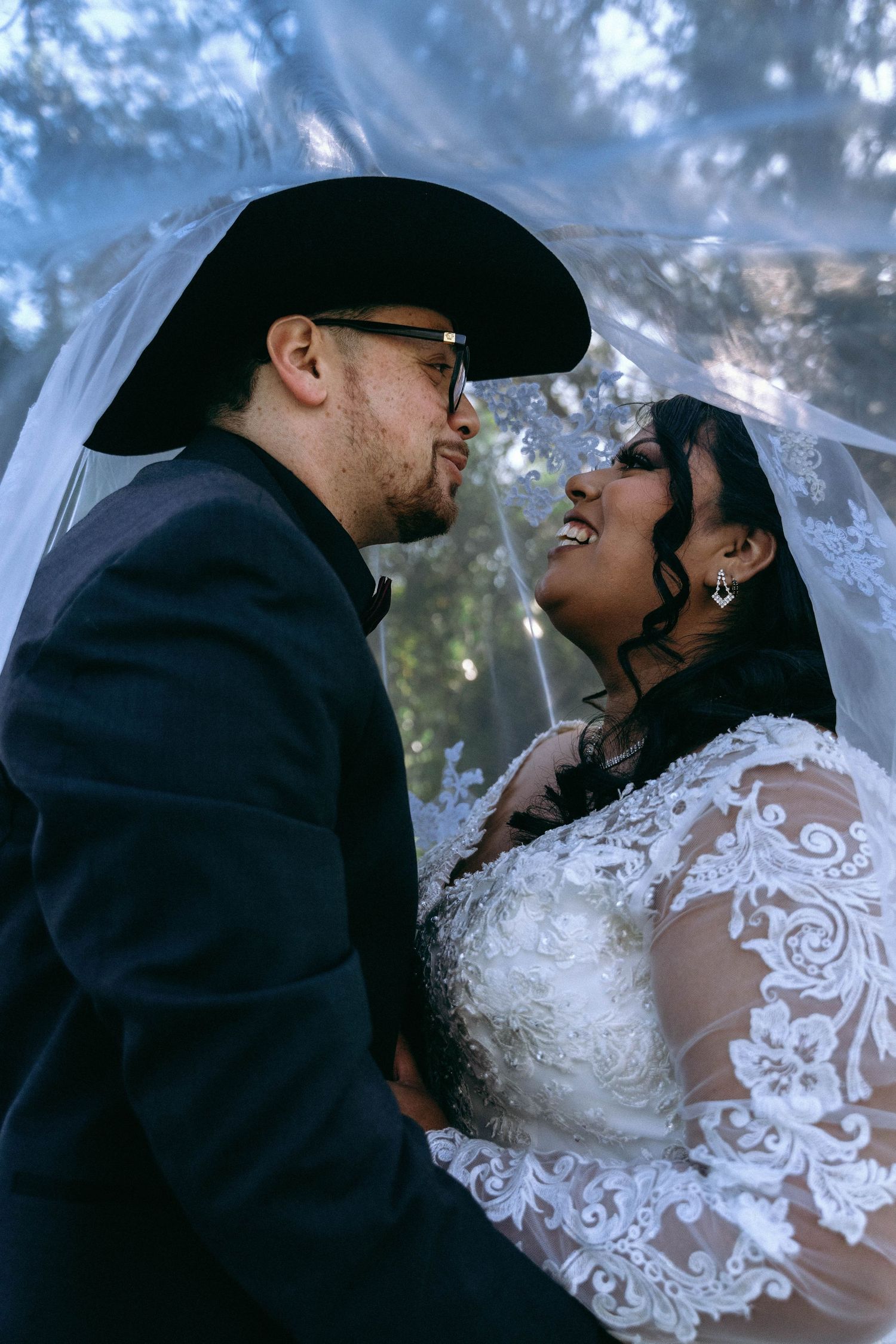 A romantic wedding photoshoot capturing intimate moments between newlyweds against a dusky blue background.