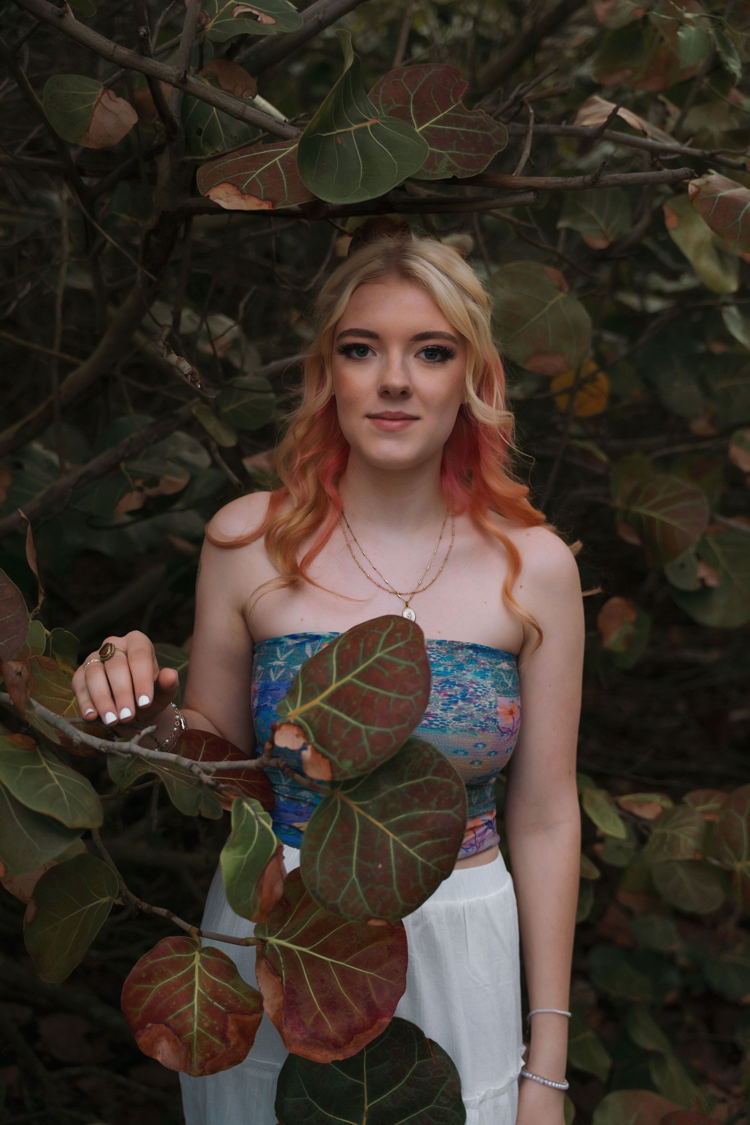 A summer outfit photographed among large tropical leaves and foliage.