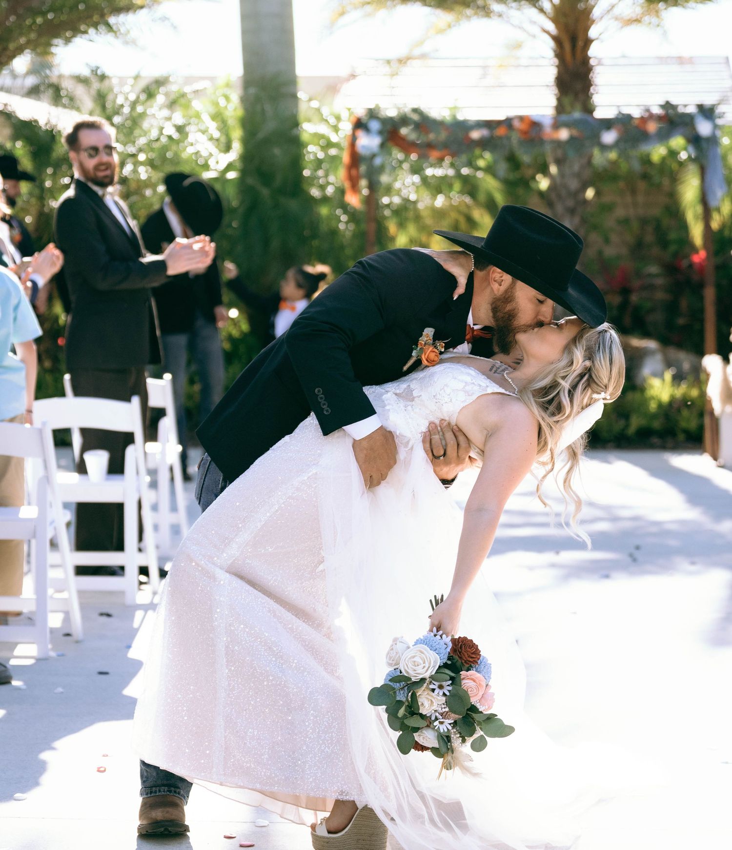 A wedding couple dances and twirls outdoors with the bride's white dress flowing dramatically.