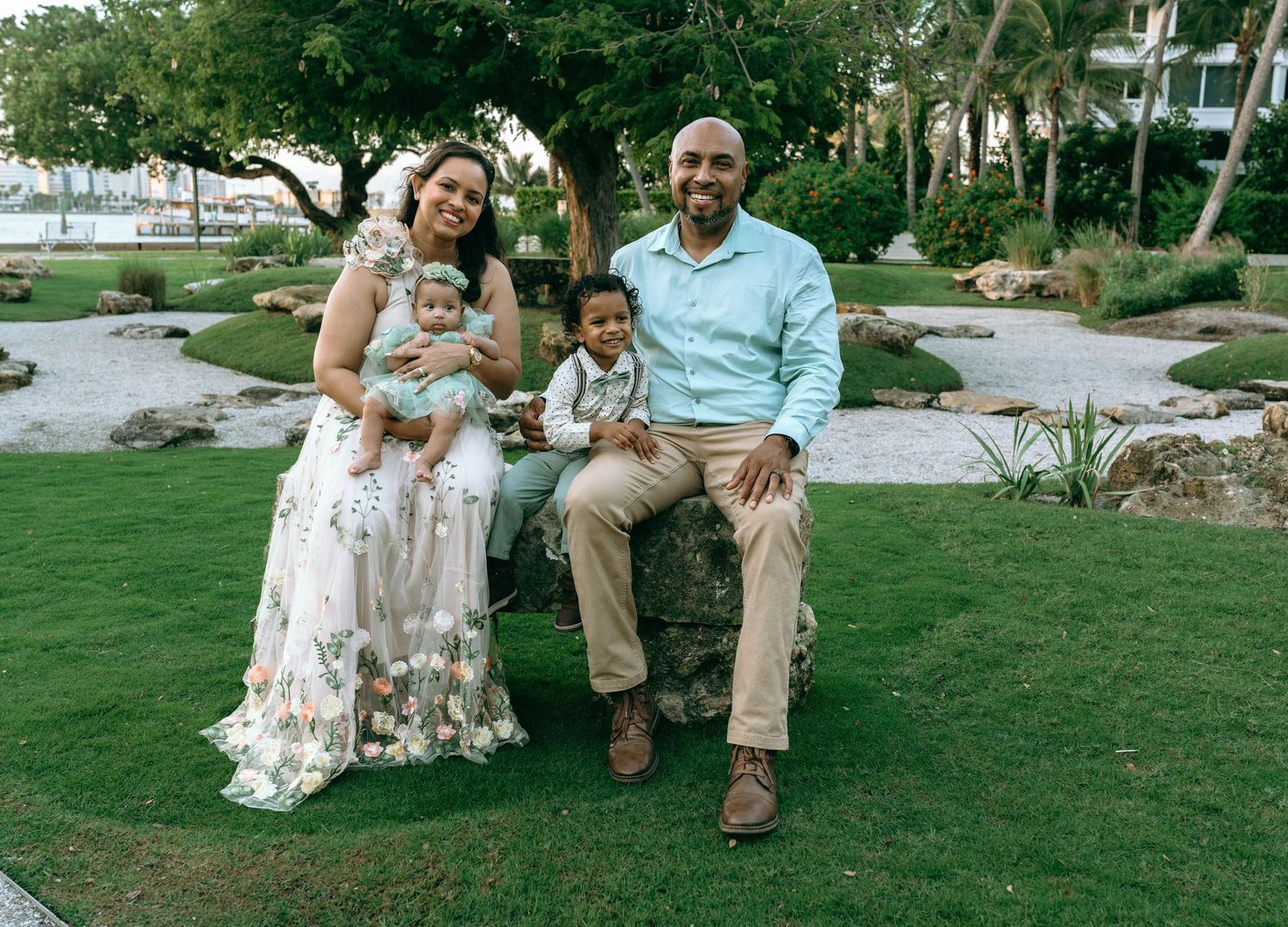 Family sitting together on grass during outdoor photo session.