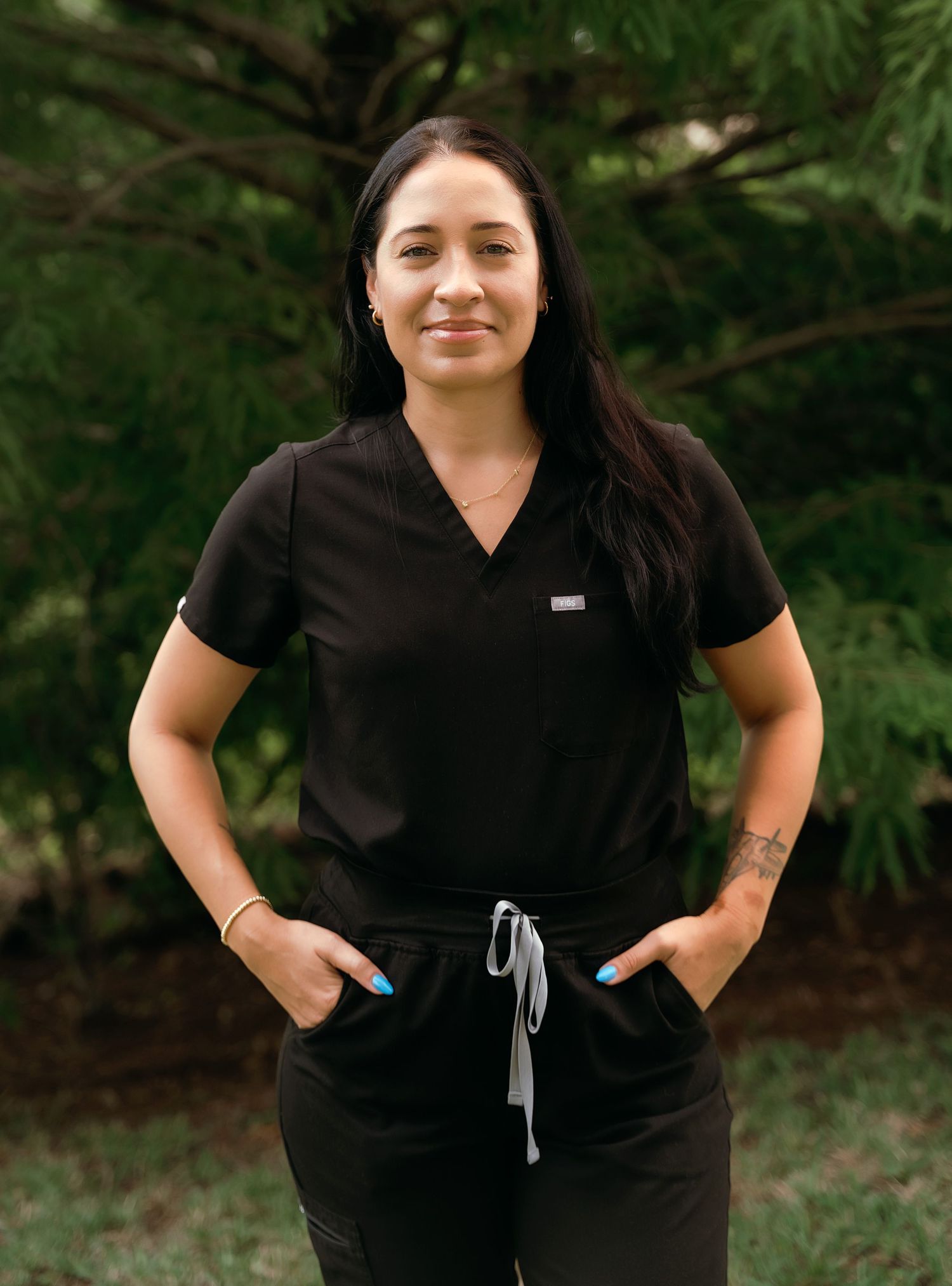 Outdoor portrait series showing casual poses in black scrubs against trees.