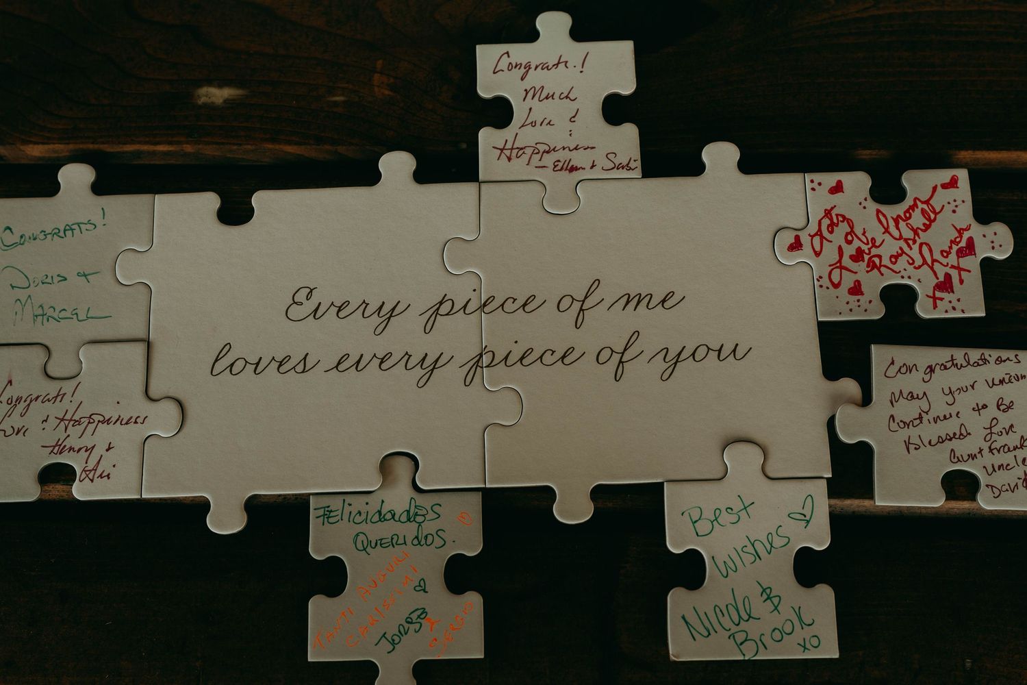 A puzzle wall display shows handwritten messages and quotes on individual pieces against a dark wooden background.