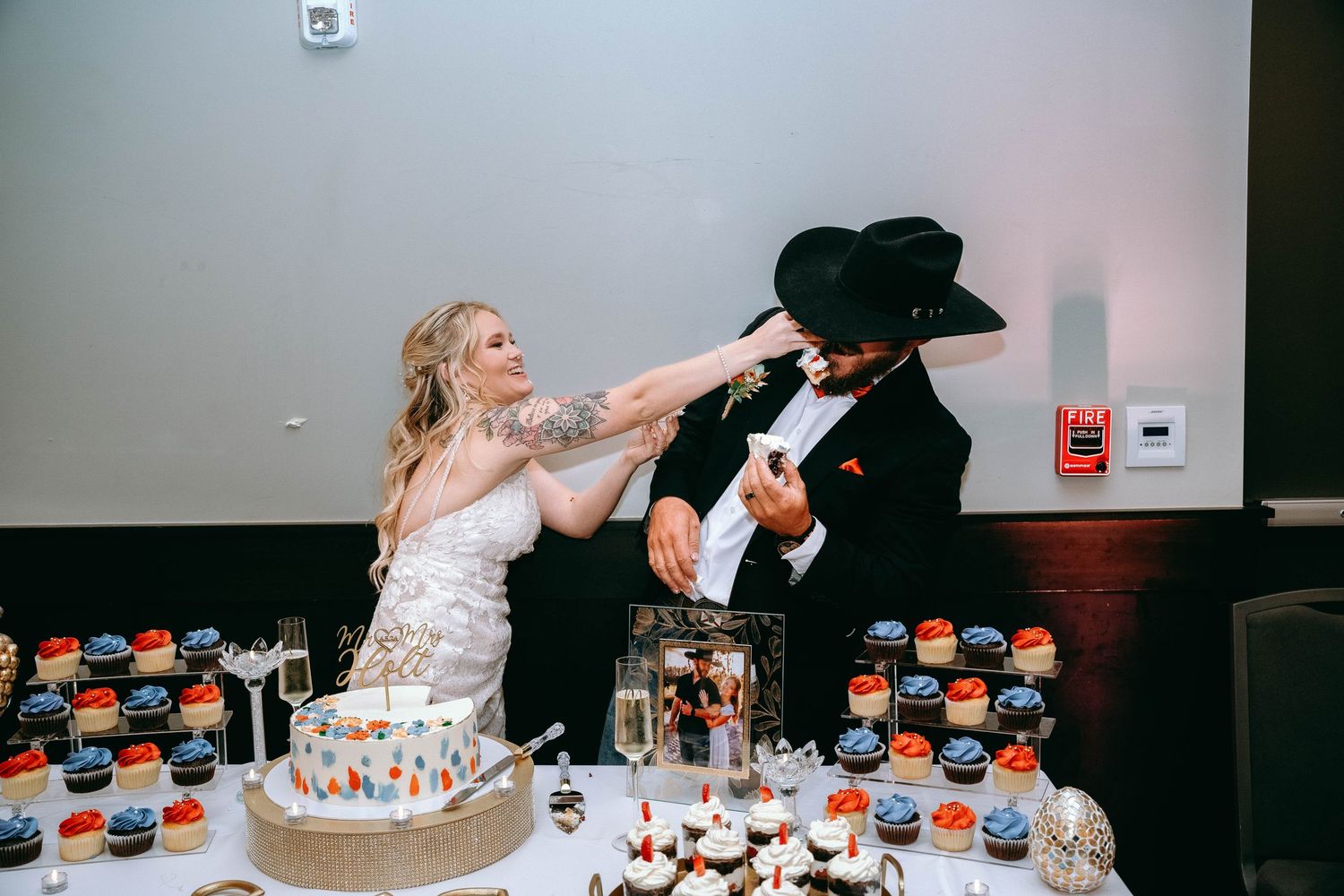 A playful cake smashing sequence at what appears to be a wedding reception with black and white formal attire.
