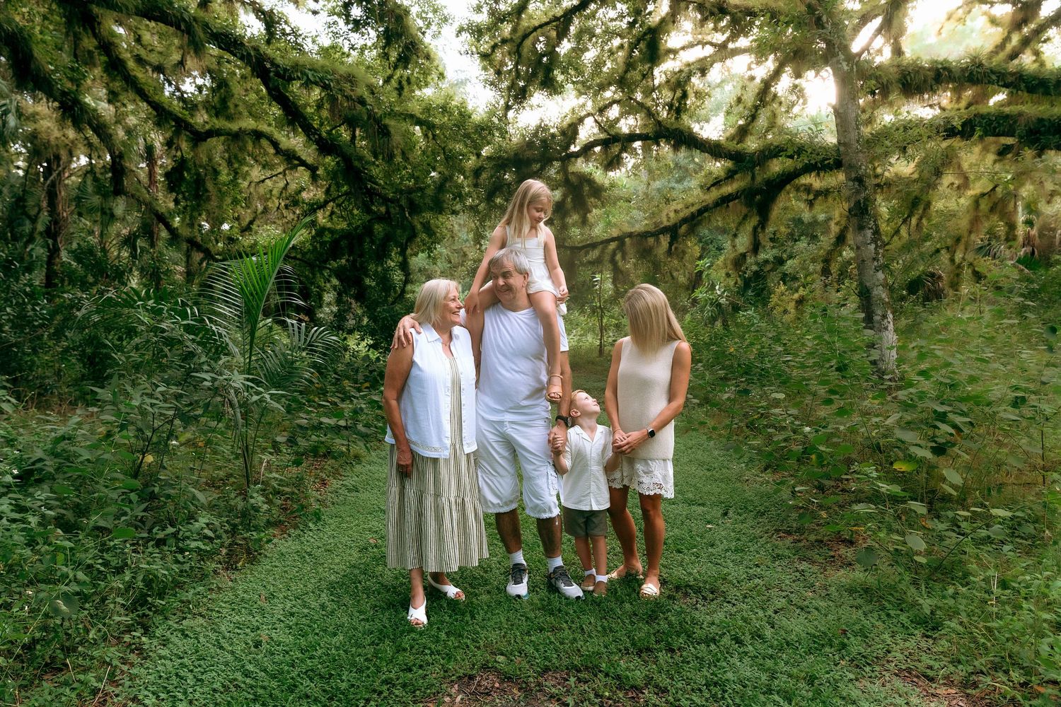 Family group enjoying a casual photo session in a natural garden setting.