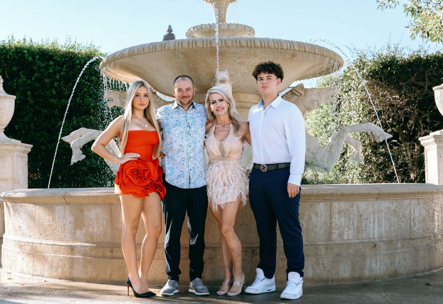 Group photo session around a decorative stone fountain.