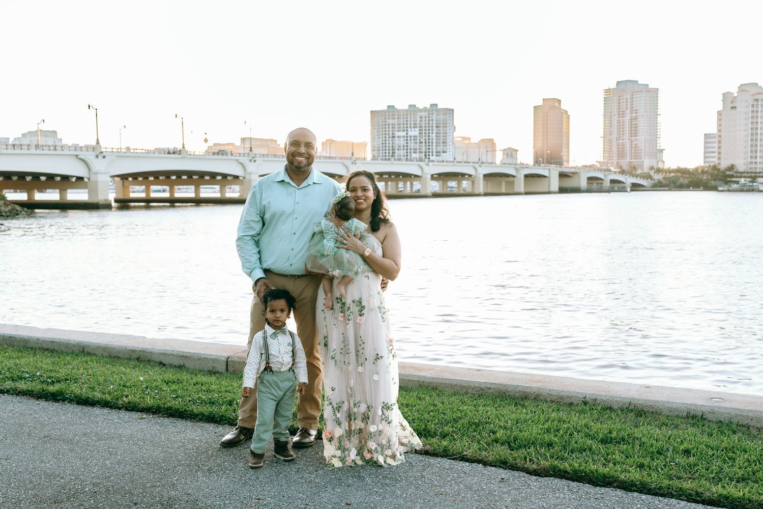 Family portrait session near waterfront with city skyline in background.