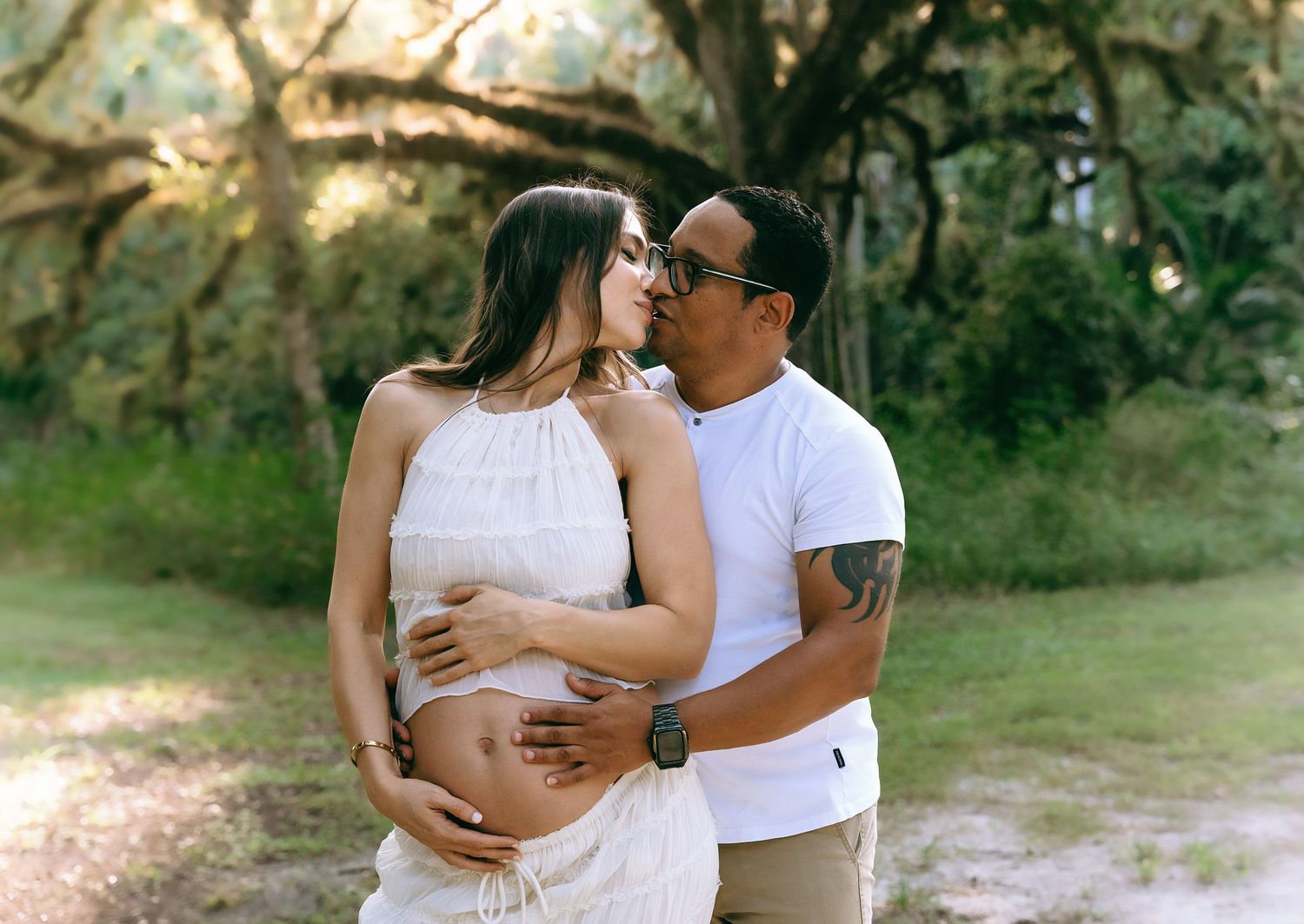 Intimate maternity portraits in natural outdoor setting during golden hour.