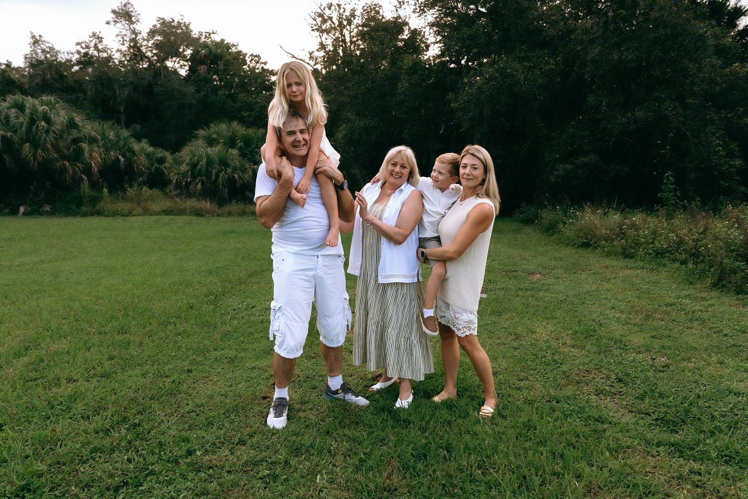Group in coordinated white clothing having fun on a grassy field.