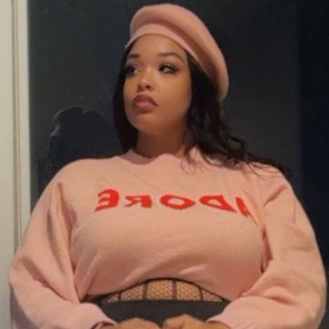 A collage of someone posing in a pink sweatshirt and matching beret against a dark background.