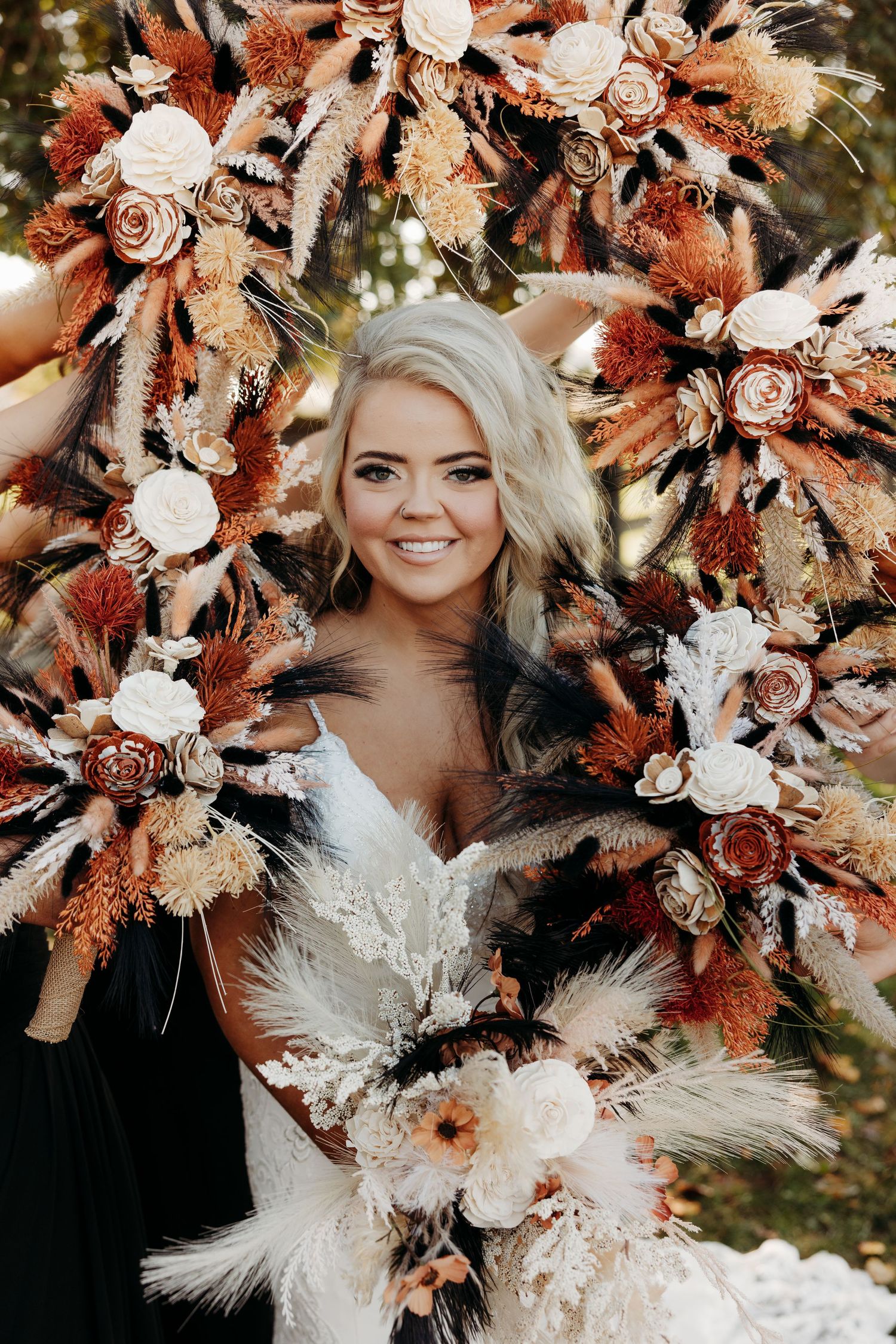 Stunning autumn wedding bouquet featuring dried flowers in coral and white with pampas grass accents.