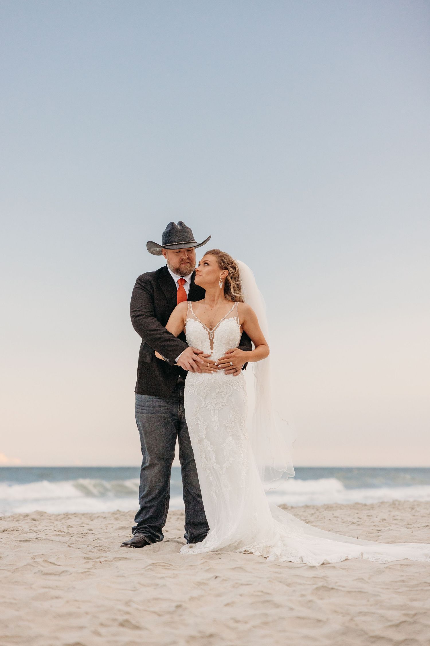 Wedding couple shares tender moments on a pristine white sand beach.