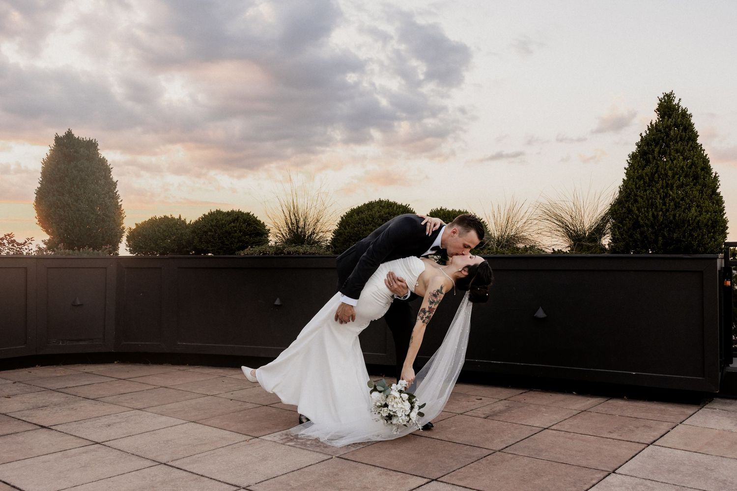 Romantic sunset wedding photoshoot on rooftop terrace with dramatic sky at Frazier History Museum.