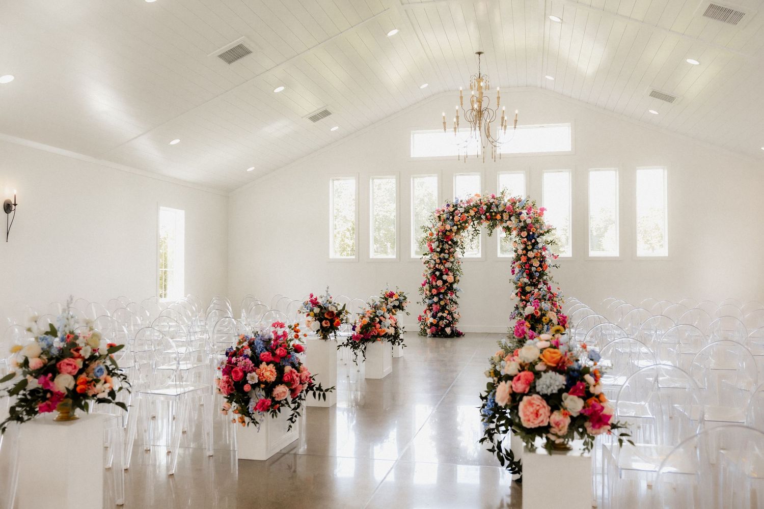 Elegant white wedding chapel in Radcliffe, KY decorated with floral arrangements and chandeliers.