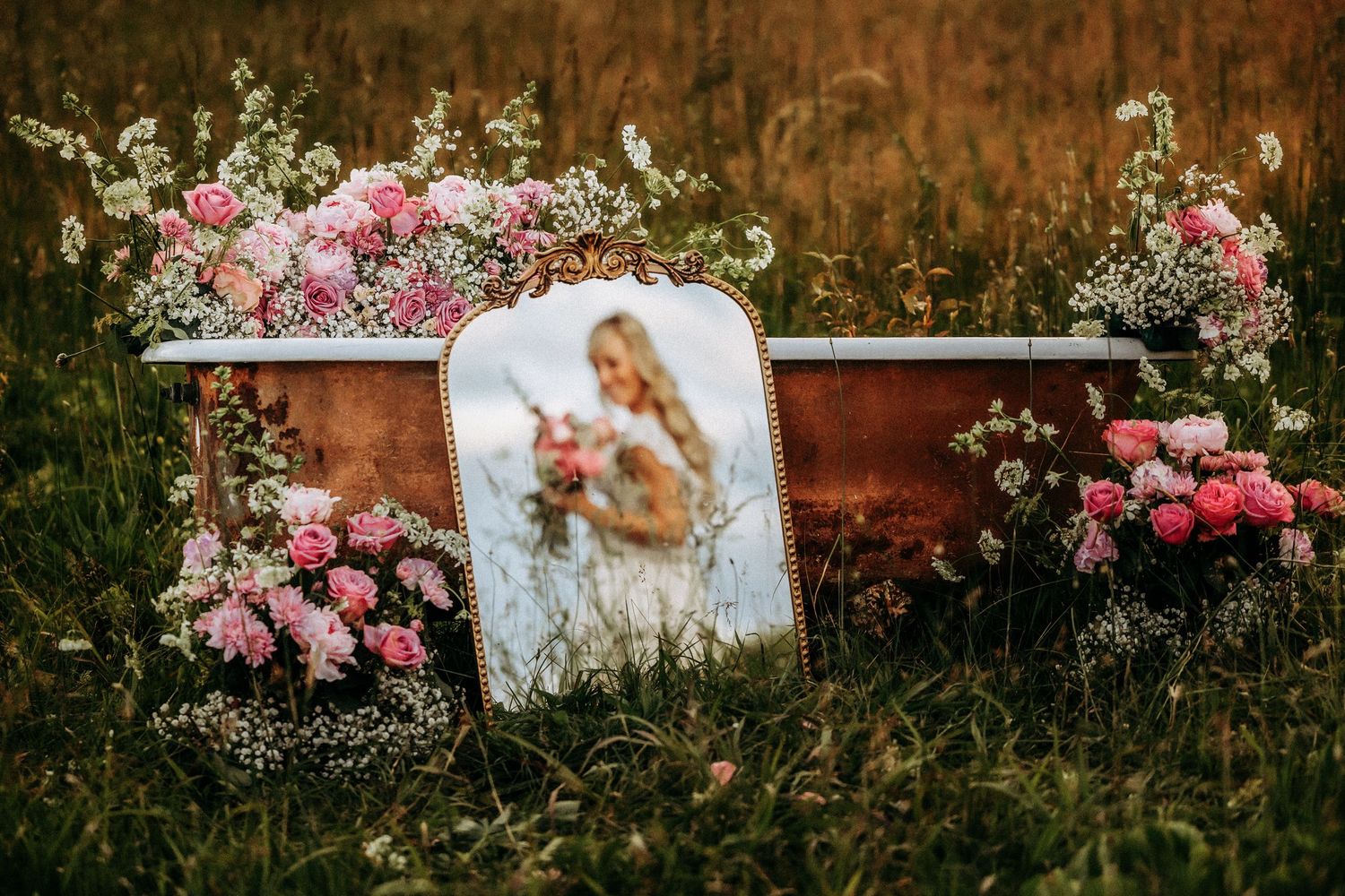A rustic brown wall adorned with climbing pink roses creates a romantic garden backdrop.