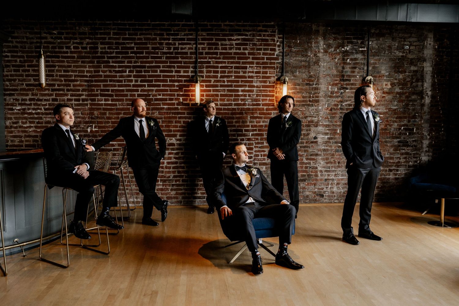 Wedding party members in formal attire gathered in industrial brick venue space at The Frazier History Museum.