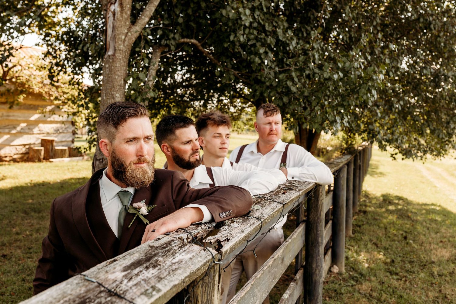 Wedding party posing casually on a rustic wooden fence at The Cornerstone Acres wedding venue in Springfield, KY.