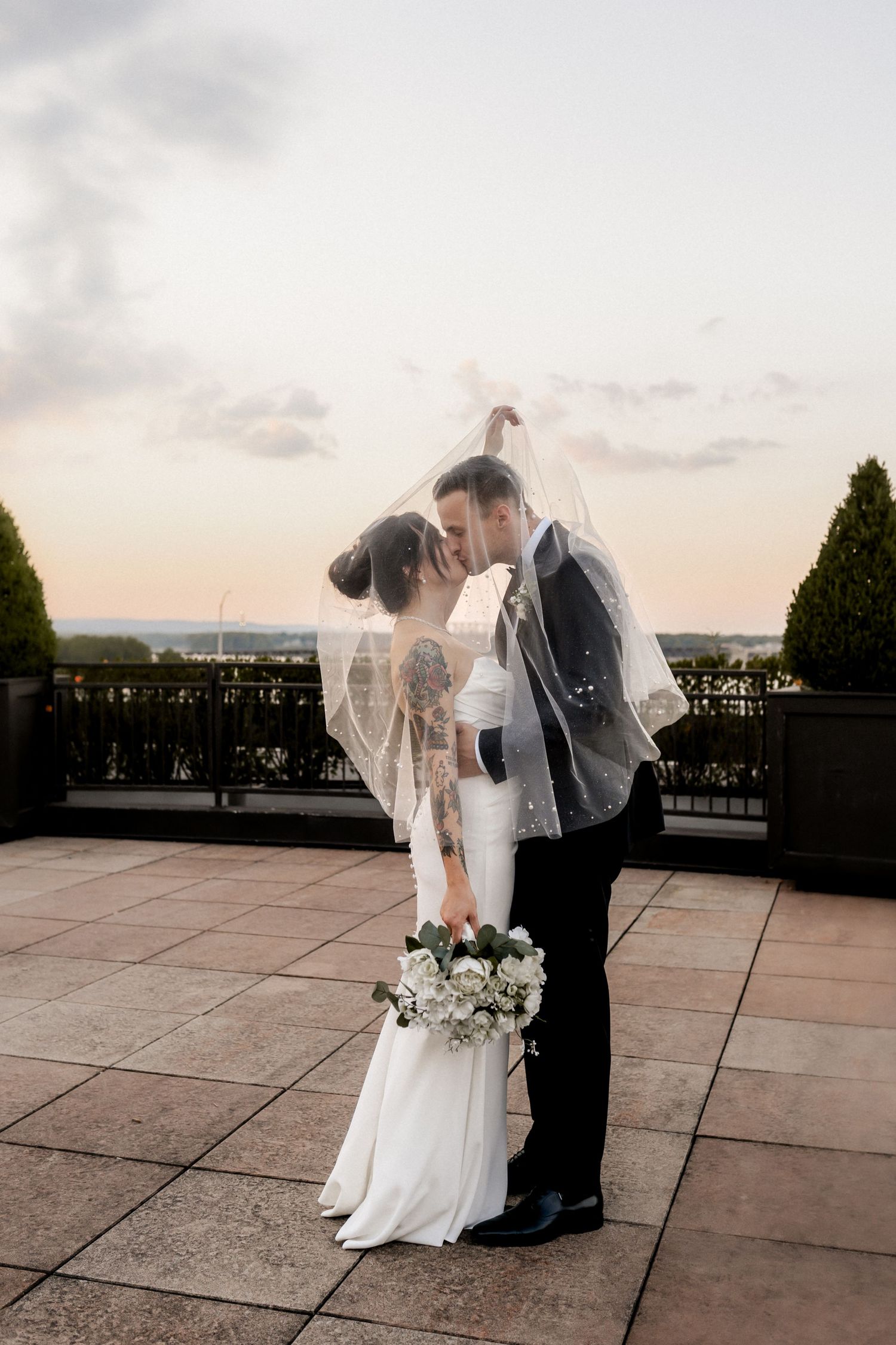 Wedding couple dances together on outdoor terrace during golden hour at The Frazier History Museum in Louisville, KY.