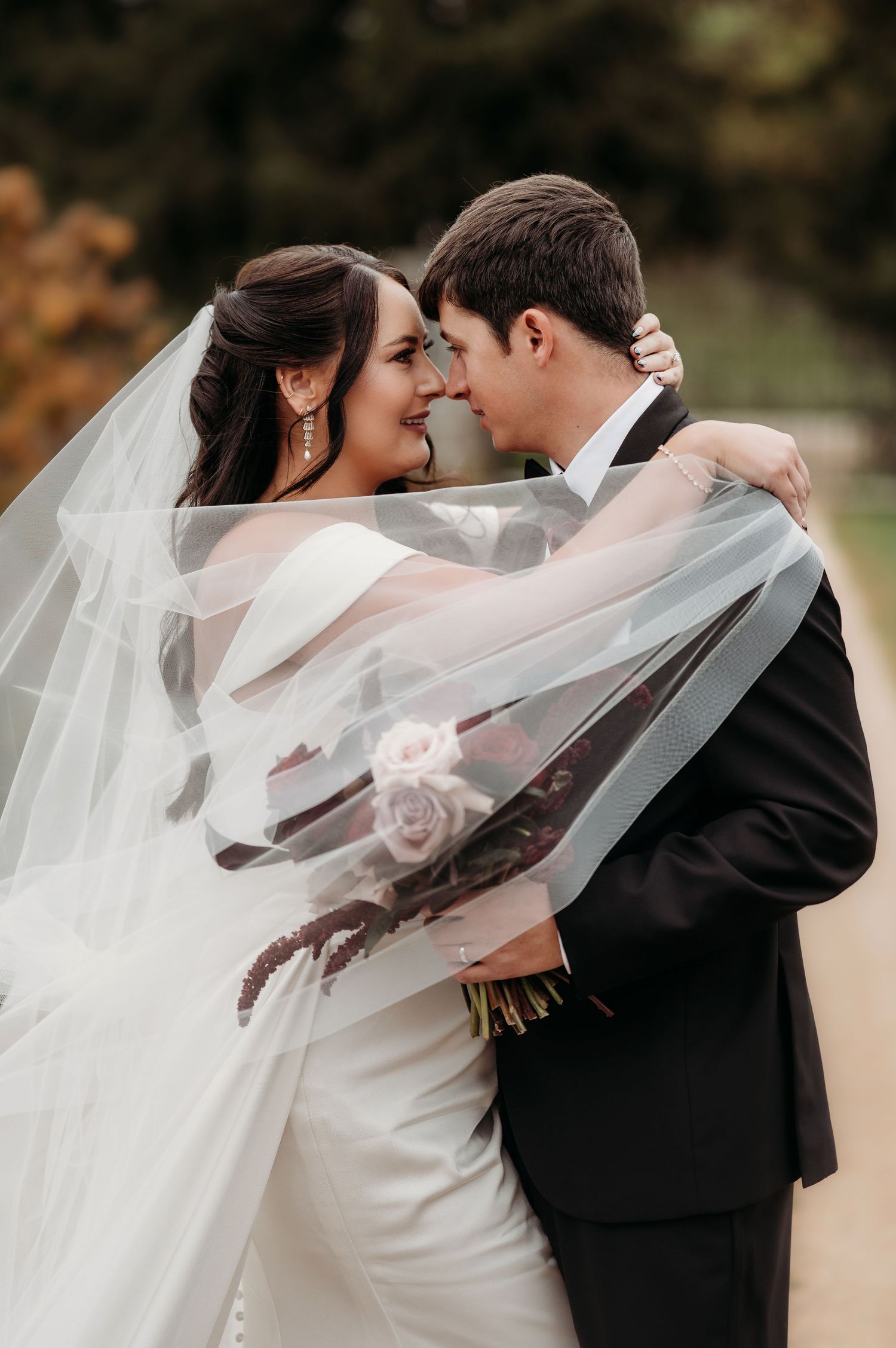 Romantic wedding portrait with flowing white veil against Simmstown Manor autumn backdrop.