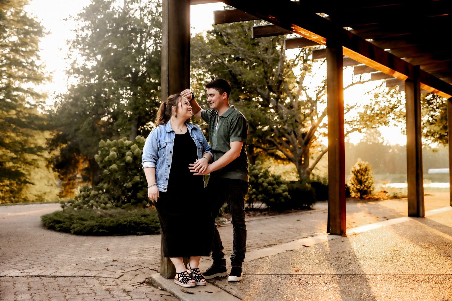 A couple shares an intimate moment under a covered porch during sunset.