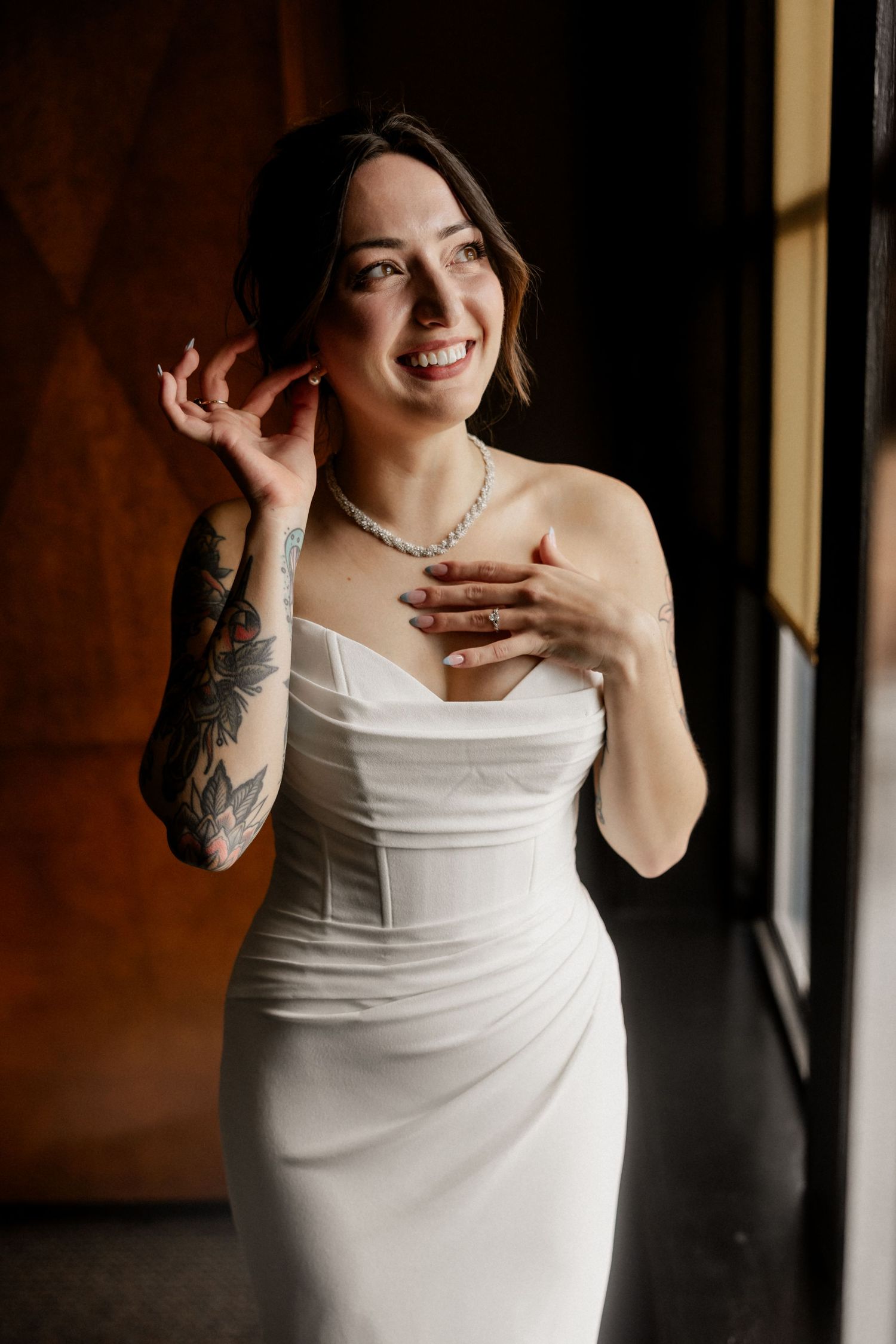Elegant white wedding dress captured in intimate indoor bridal portrait session.