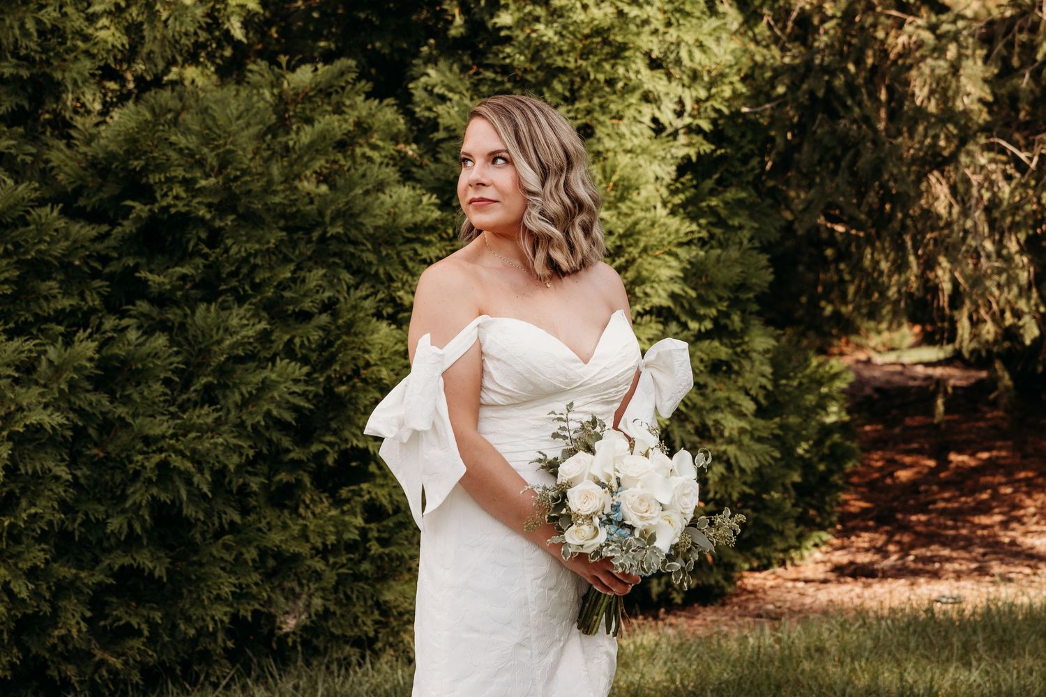 Bridal portraits with white bouquet in an outdoor garden setting.