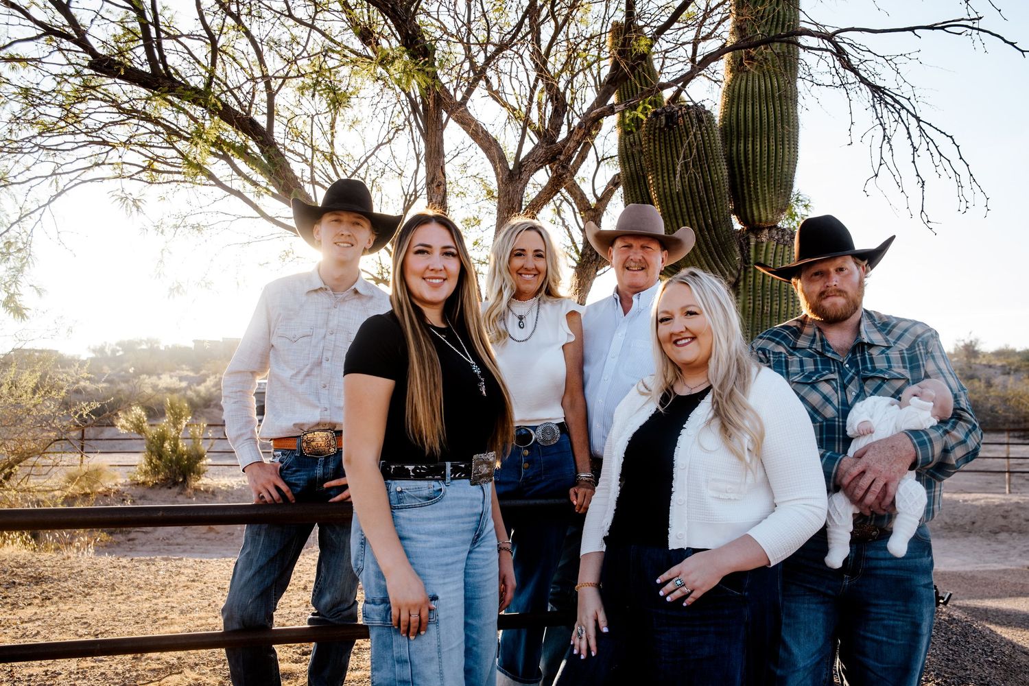 Family group portrait in western attire against a desert landscape at sunset in Wickenburg, AZ.