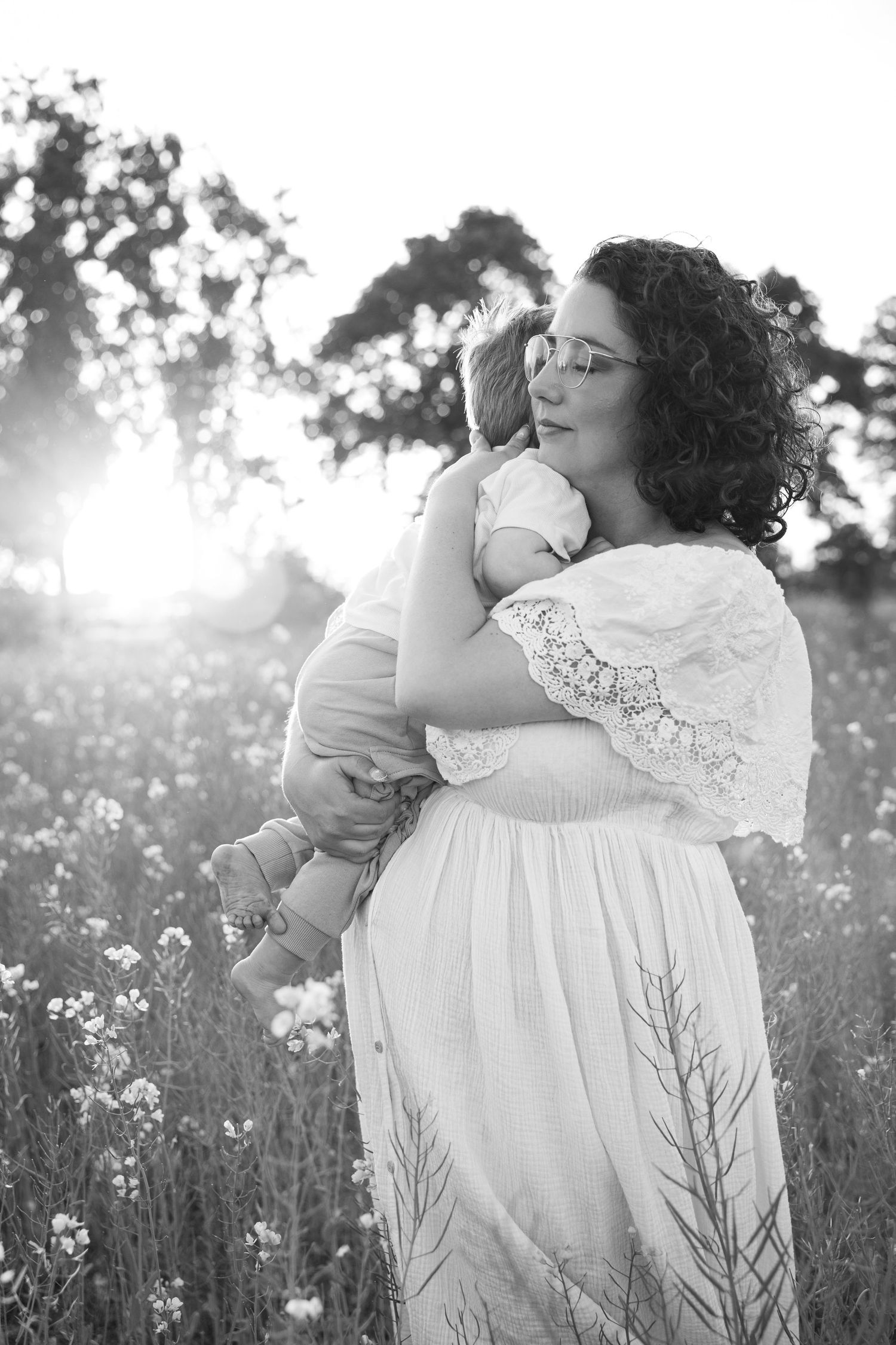 Motherhood shoot tussen bloeiende bloemen in Noord-Brabant. Intieme moeder-kind foto's in de natuur nabij Eindhoven, zacht en liefdevol.